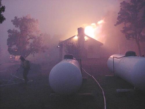 Night photos of a house burning during the Long Mesa fire in Mesa Verde National Park, July-August 2002