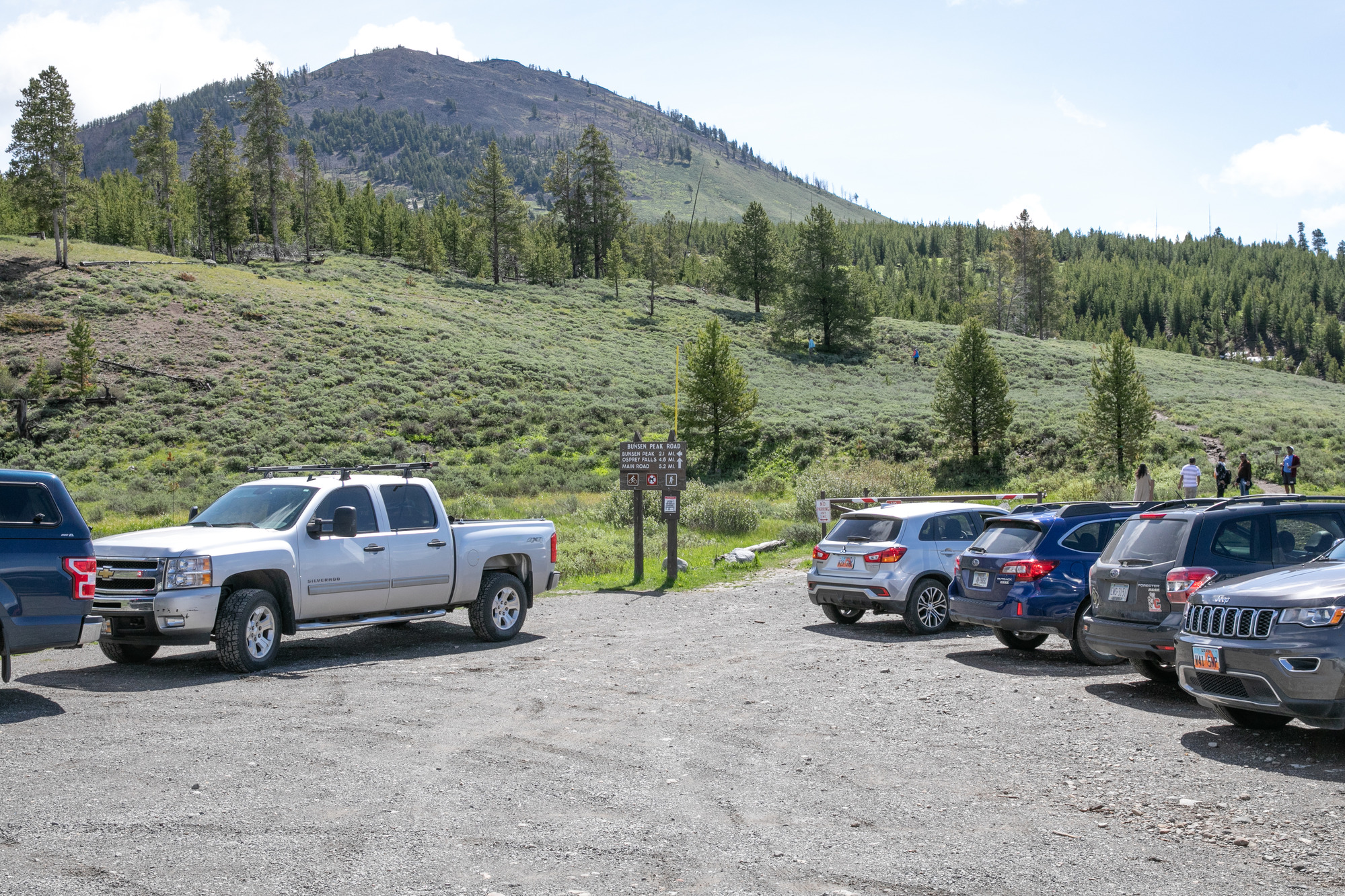 Vehicles in parking area and people walking on trail