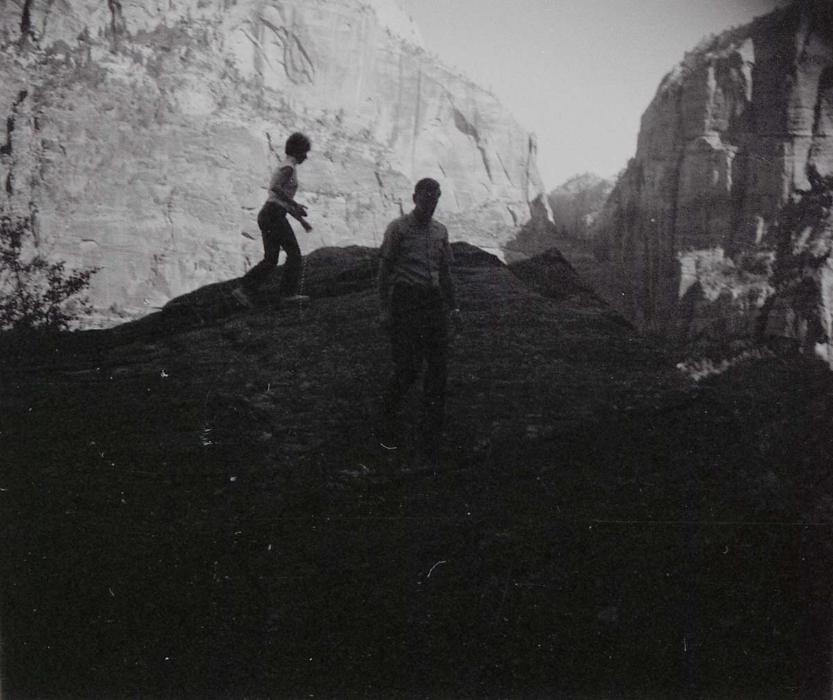 Man and woman on slickrock near water tanks involved in reroofing project.