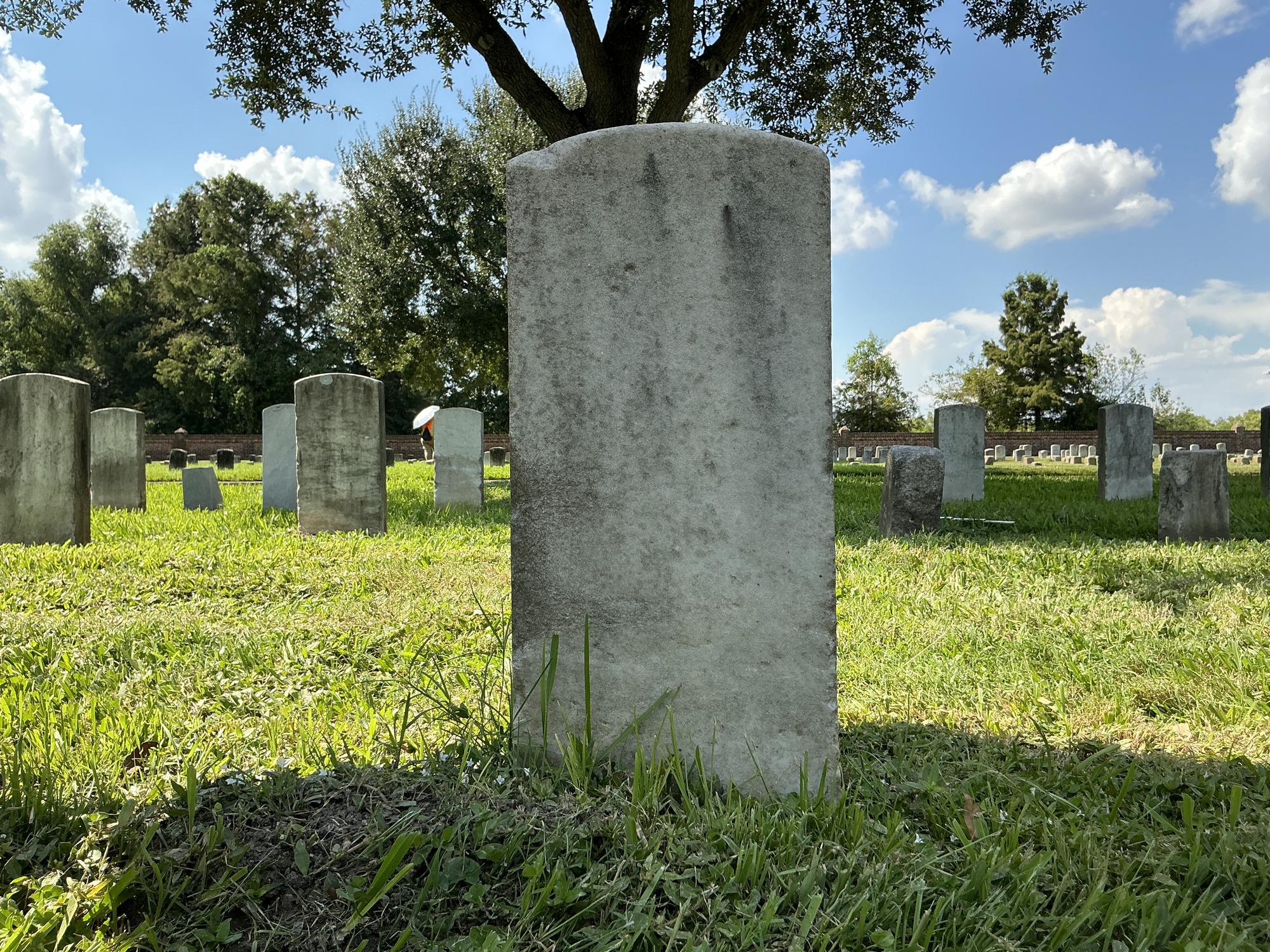 Back of historic upright marble headstone with recessed shield face.