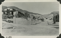 This is an historic black and white photograph from the Scotty's Castle Historic Photograph Collection, Death Valley National Park looking northeast, Scotty's Castle Hacienda nearly complete. Scotty's Original Castle and Stables in background. About 1930 or 1931. Photographed by Mat Roy Thompson.