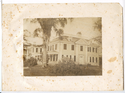 Black and white photograph of Georgian mansion, mounted on tan paper.