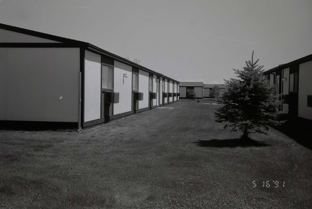 Backside of barracks with landscaping between buildings. [Image possibly for comparative housing study]