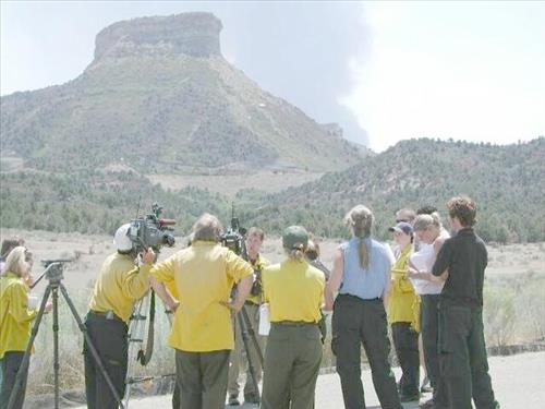 News media and park staff observe fire from a parking lot as a white smoke plume rises vertically over Long Mesa, Long Mesa Fire, Mesa Verde National Park, July-August 2002