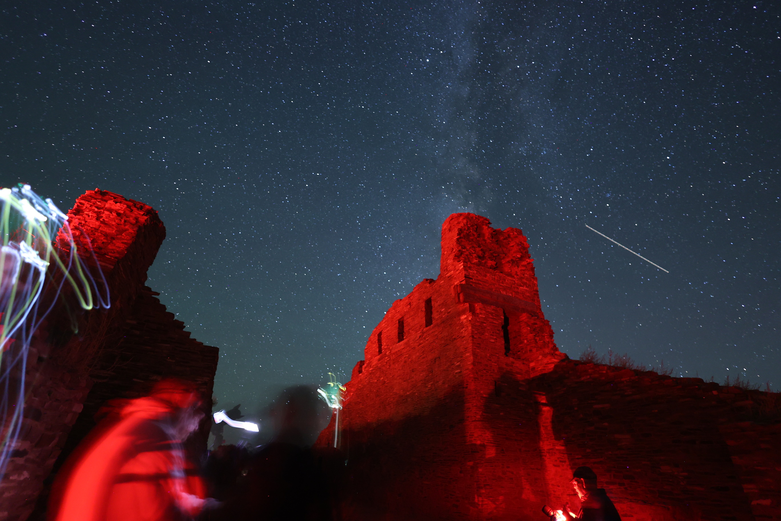 Milky Way in a starry sky with red sandstone church remnants in the foreground.