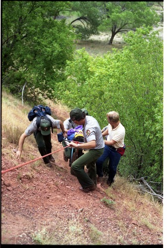 Color photo of SAR team transporting injured man.