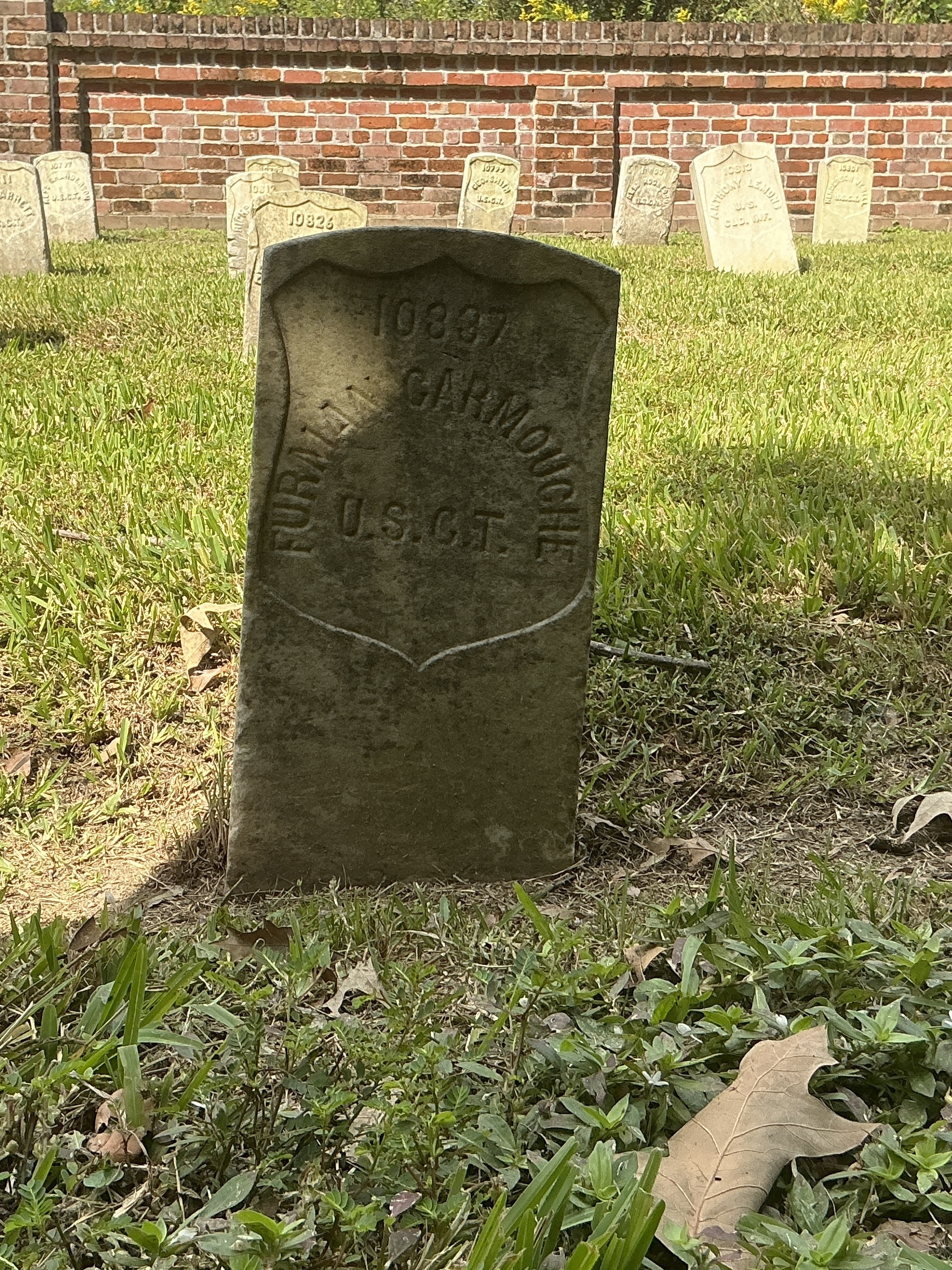 Front of historic upright marble headstone with recessed shield face.