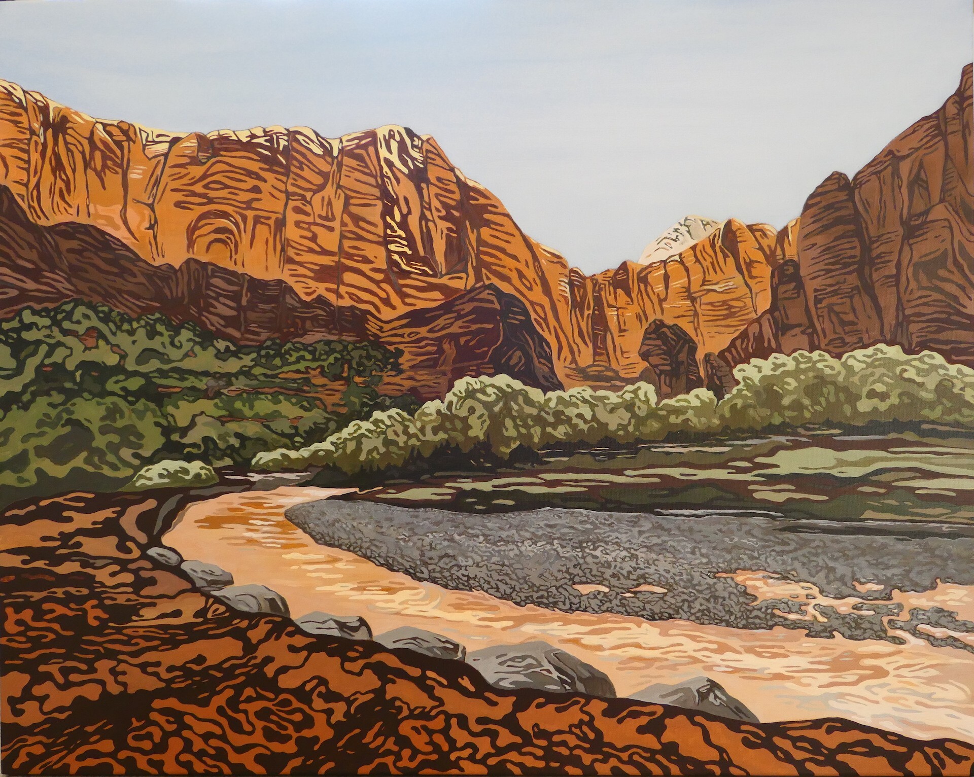 Orange and brown sandstone cliffs over green vegetation and a tan river.