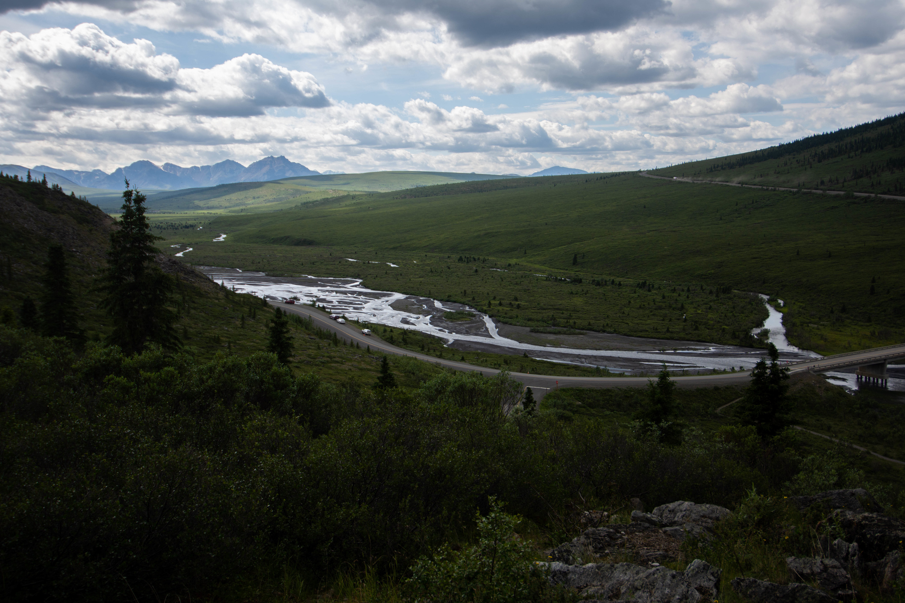 a road winding near a river and bridge