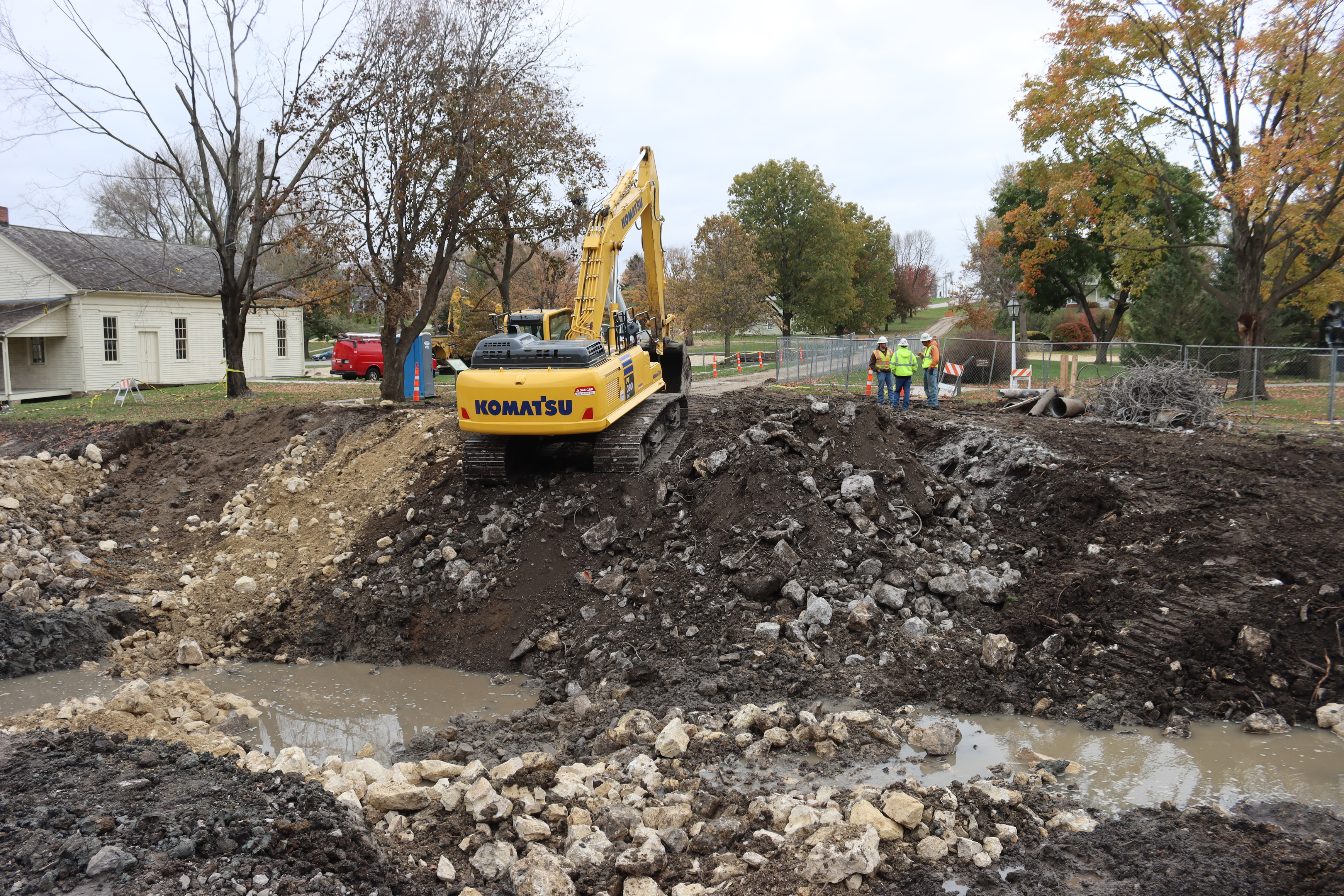 An excavator is perched on the bank of the creek at the site of the Downey Street Bridge. 