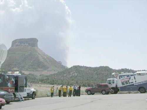 News media and park staff observe fire from a parking lot as a white smoke plume rises vertically over Long Mesa, Long Mesa Fire, Mesa Verde National Park, July-August 2002