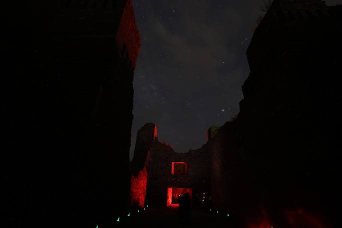 Dark sky photo with dark church remnants in the foreground.