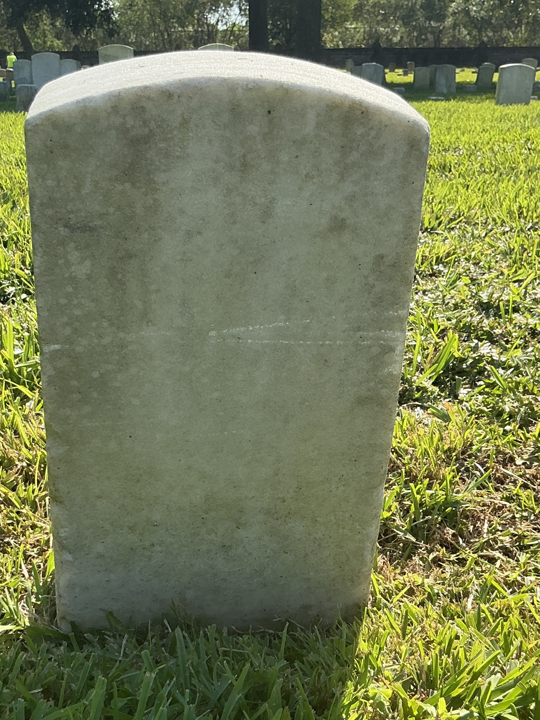 Back of historic upright marble headstone with recessed shield face.