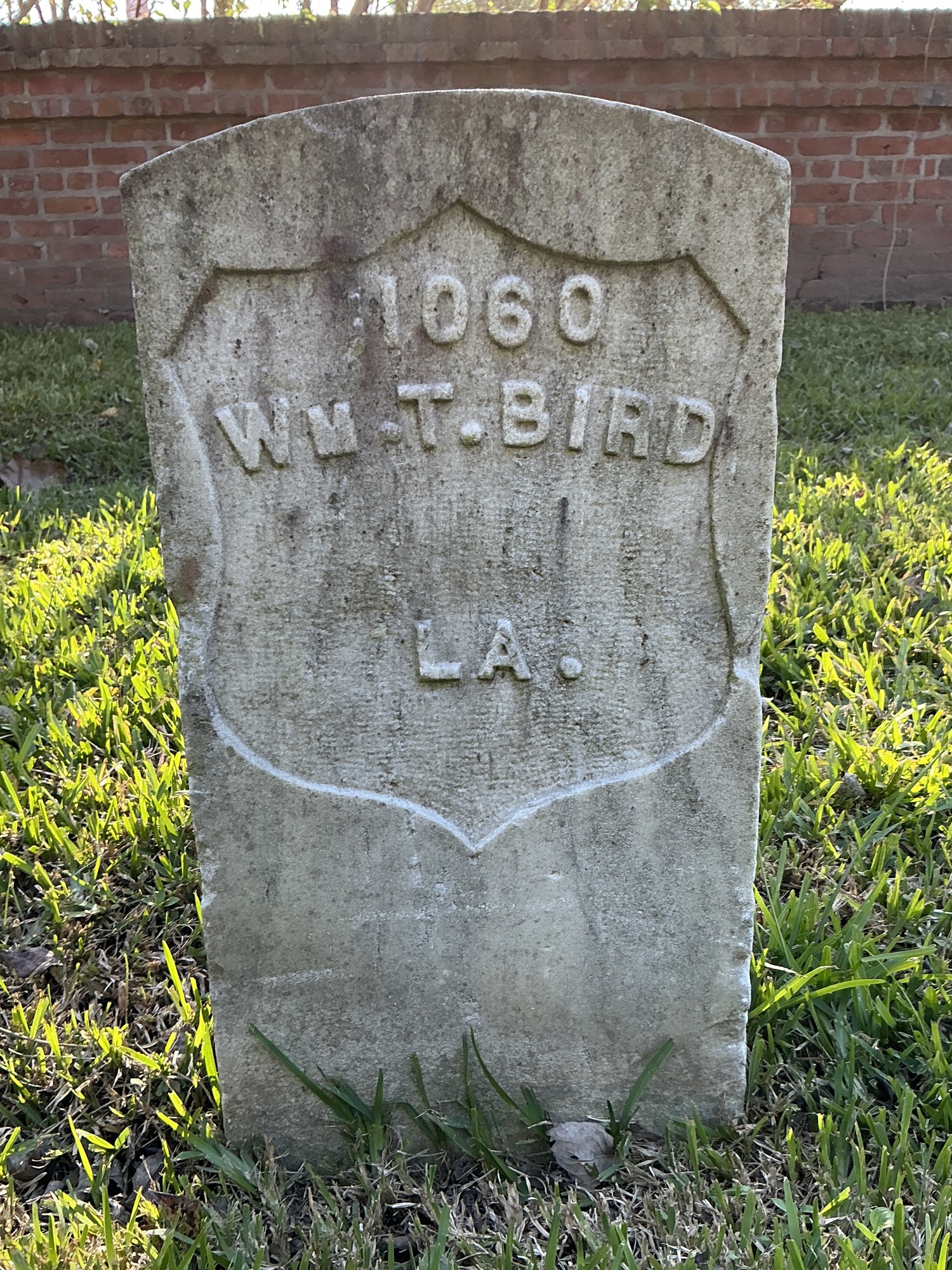 Front of historic upright marble headstone with recessed shield face.