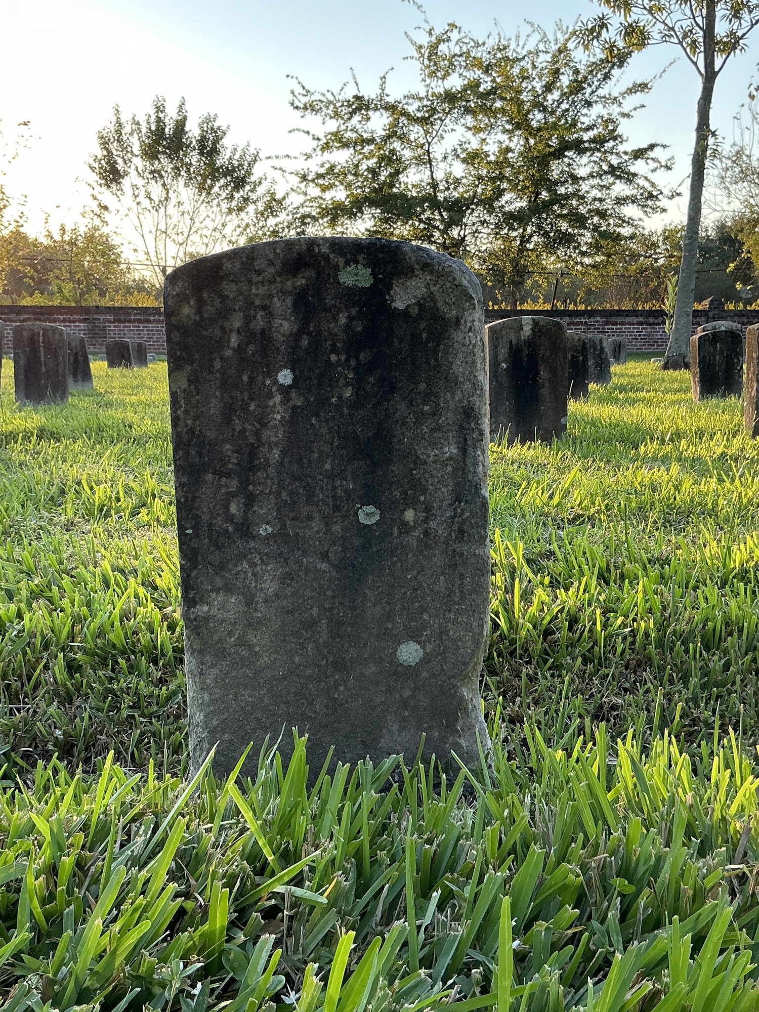 Front of historic upright marble headstone with recessed shield face.