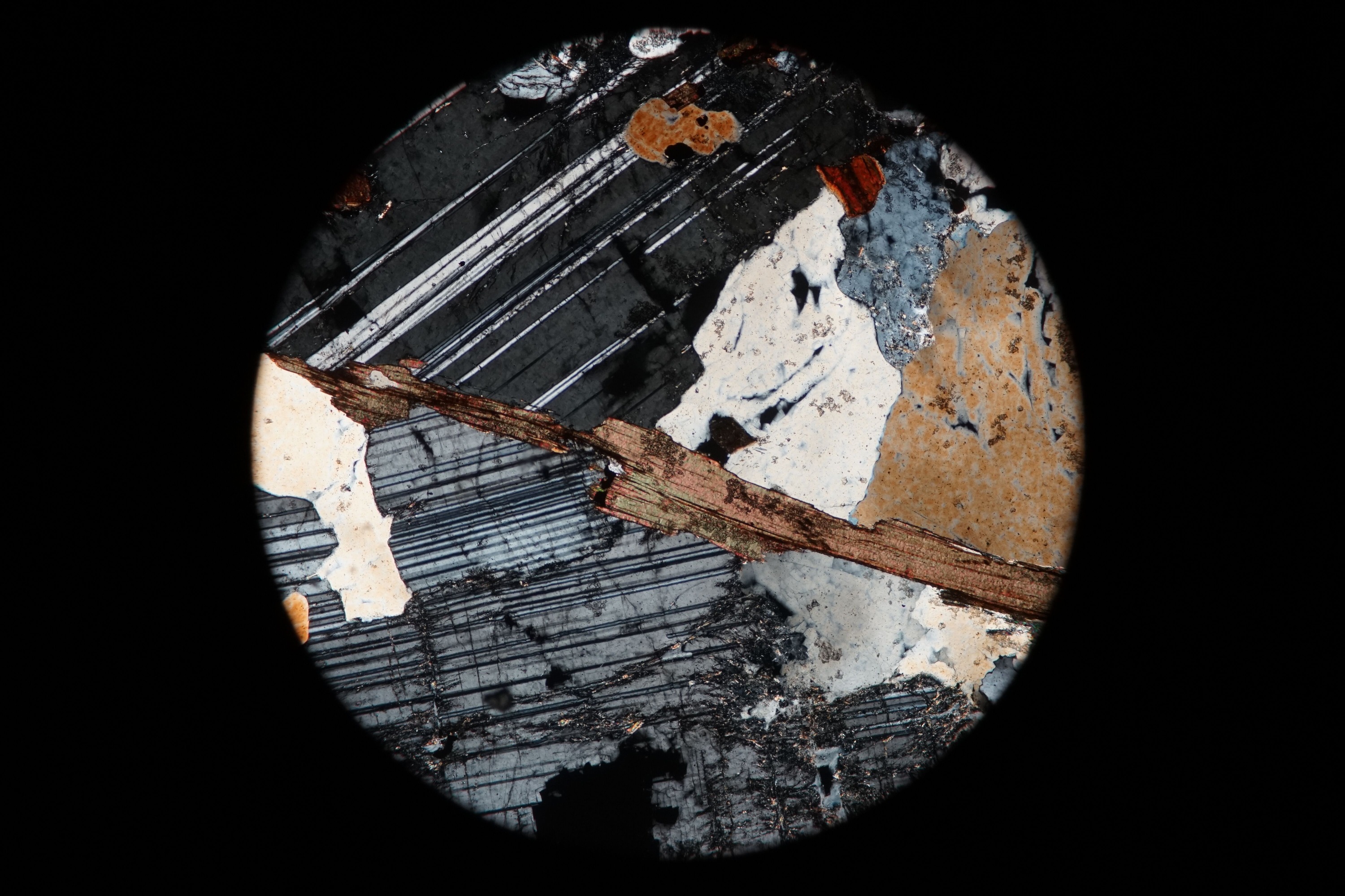 Circular microscopic image of rock structure.