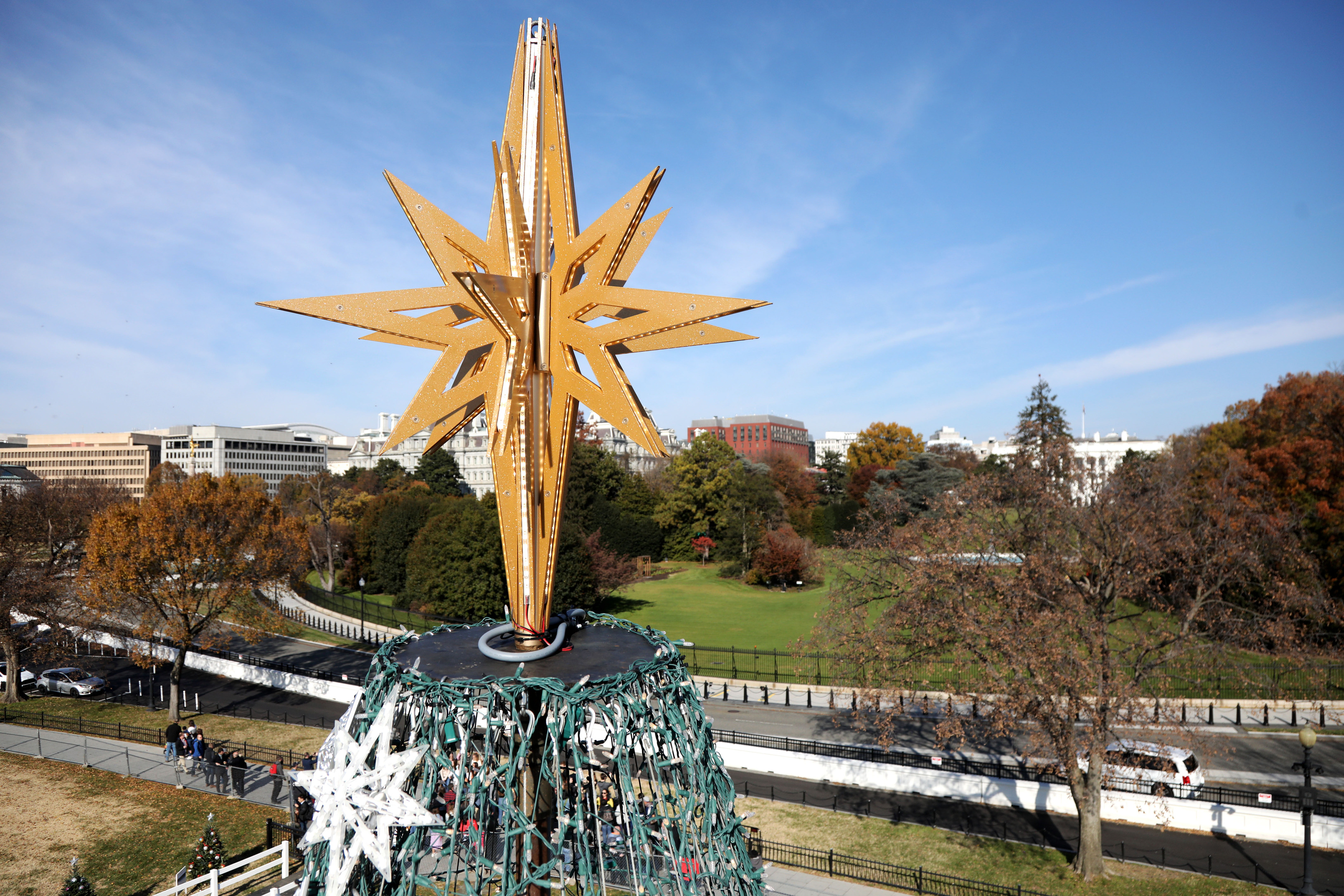 The star on top of the National Christmas Tree with the White House in the background