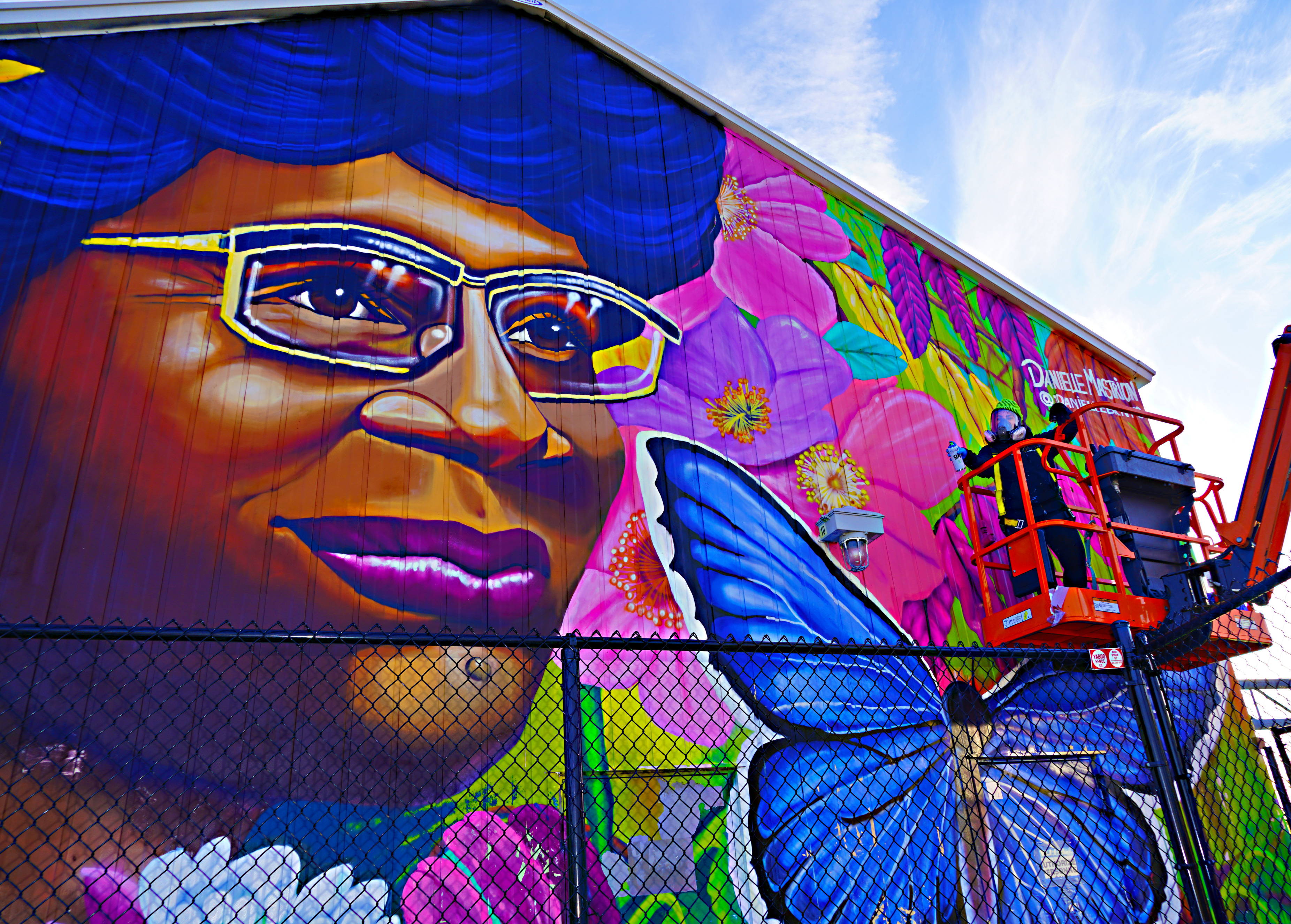 Danielle Mastrion Uses Cherry Picker to Paint Mural Of Shirley Chisholm