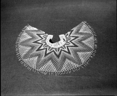 Mrs. Donald Segerstrom Collection. Object: Paiute beaded collar. Dimensions: 12 1/2 x 1 1/2". Materials: glass beads, (two shades of turquoise, two shades of orange, pink, translucent turquoise blue, clear red, milky white, transparent amber, medium blue, white, dark blue), metal hooks, thread loops. neck band single thread loomed beadwork, netted portion in vertical netting. Colors in neckband do not match colors in netted portion. Gift of E. W. Billieb, Superintendent of Mono Mills, ca. 1900. Photographed by Michael Dixon, 1/83. Catalogued by Craig Bates and Barbara Beroza. Yosemite Collections, National Park Service.