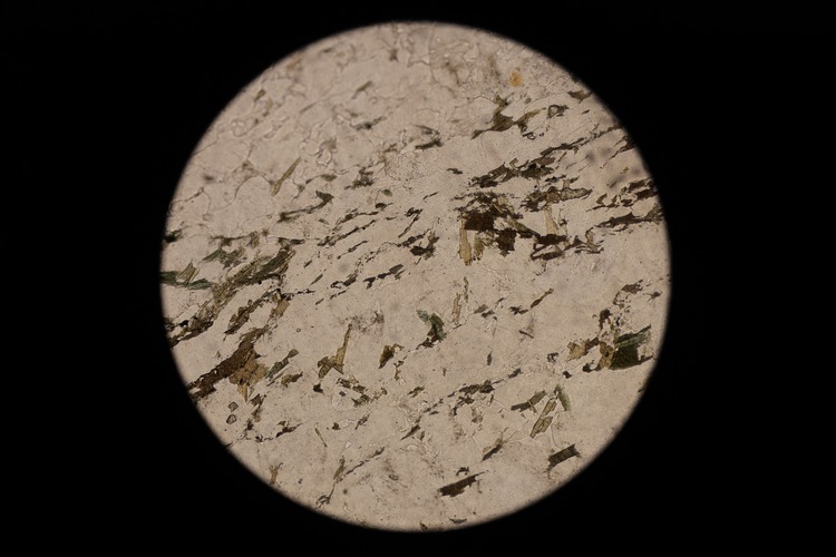 Circular microscopic image of rock structure.