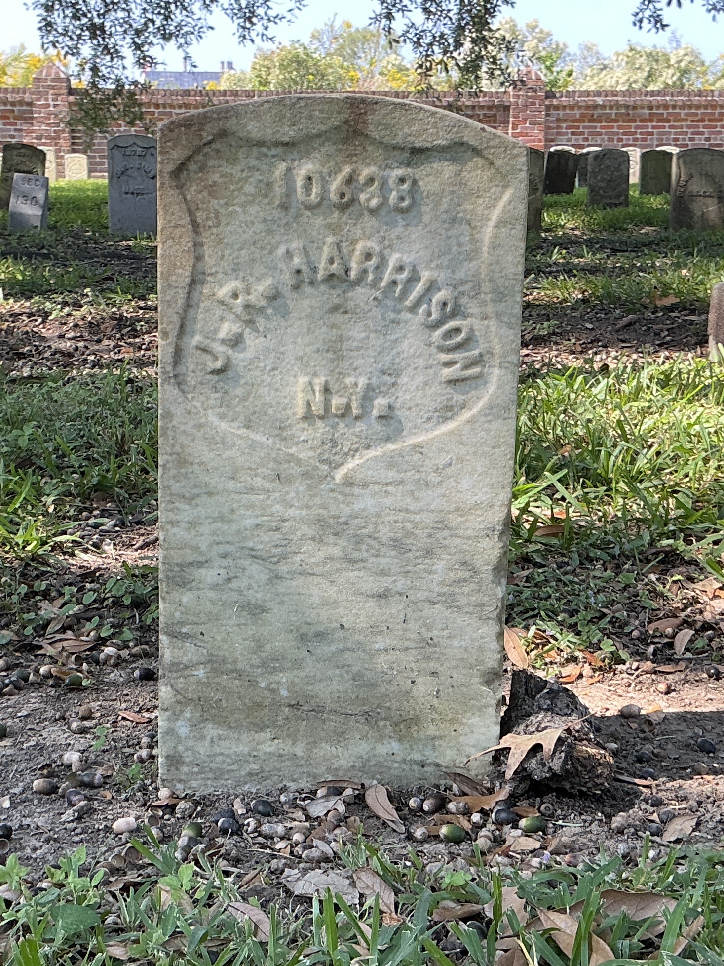 Front of historic upright marble headstone with recessed shield face.