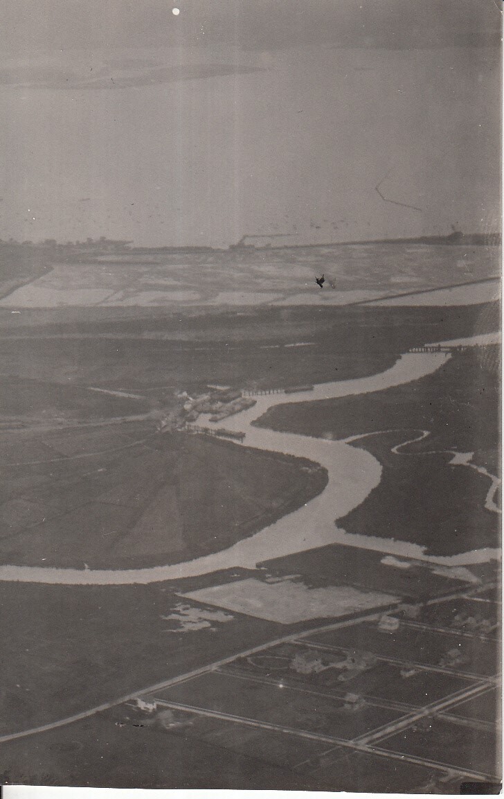 Aerial view of unidentified rural area, houses along a river.