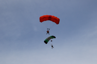 two base jumpers with parachutes fall through open sky