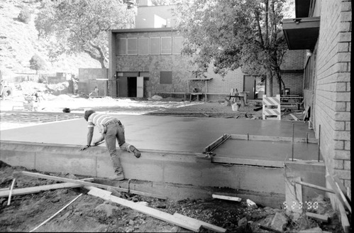 Men leveling concrete during the construction of headquarters addition.