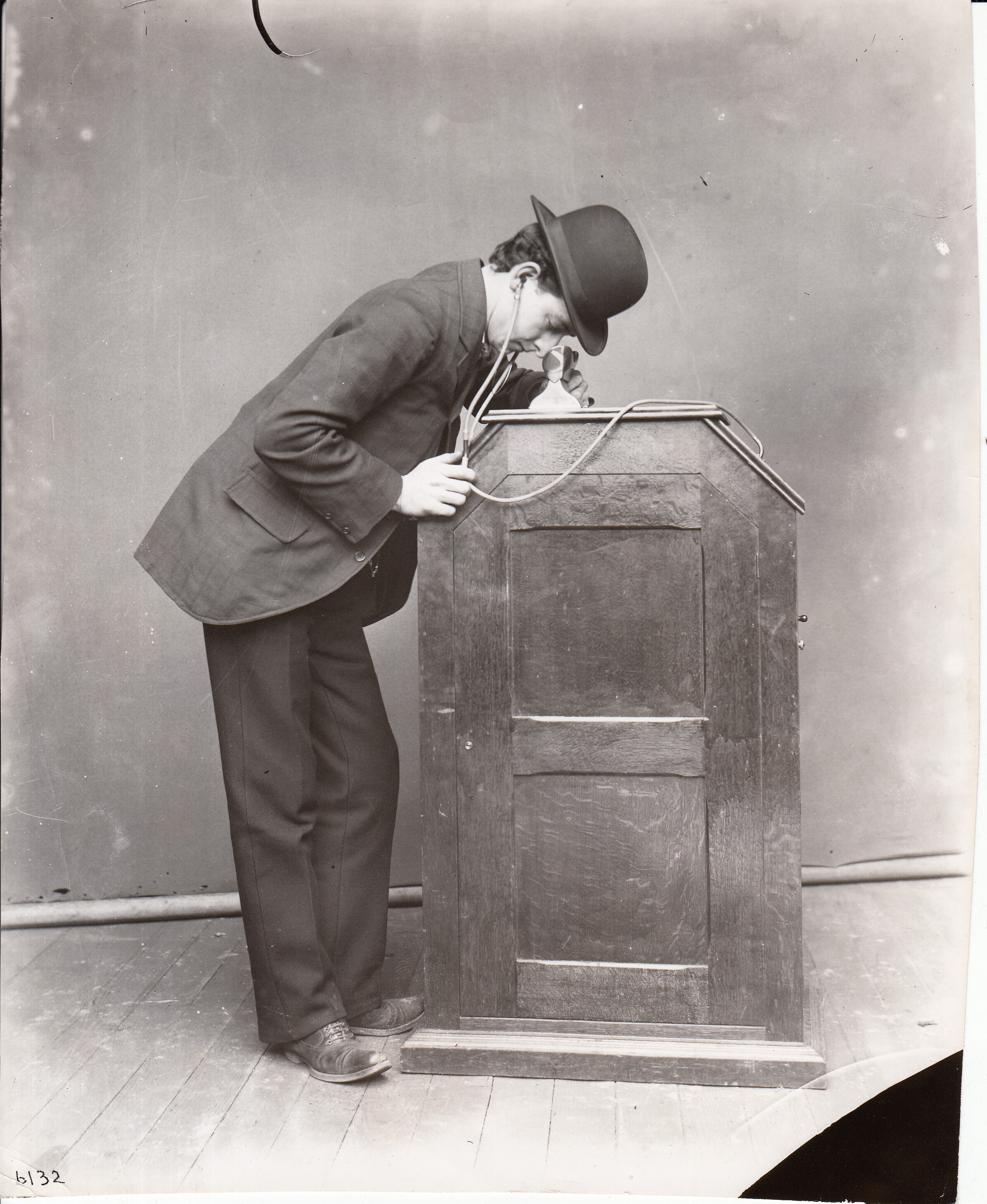 Man viewing a kinetoscope which is equipped with synchronized sound.