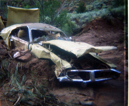 Color photos of park personnel removing a car from the flood waters of the 1975 flood.