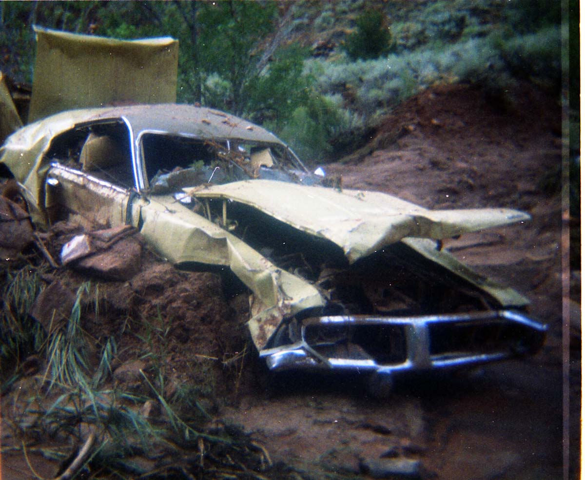 Color photos of park personnel removing a car from the flood waters of the 1975 flood.