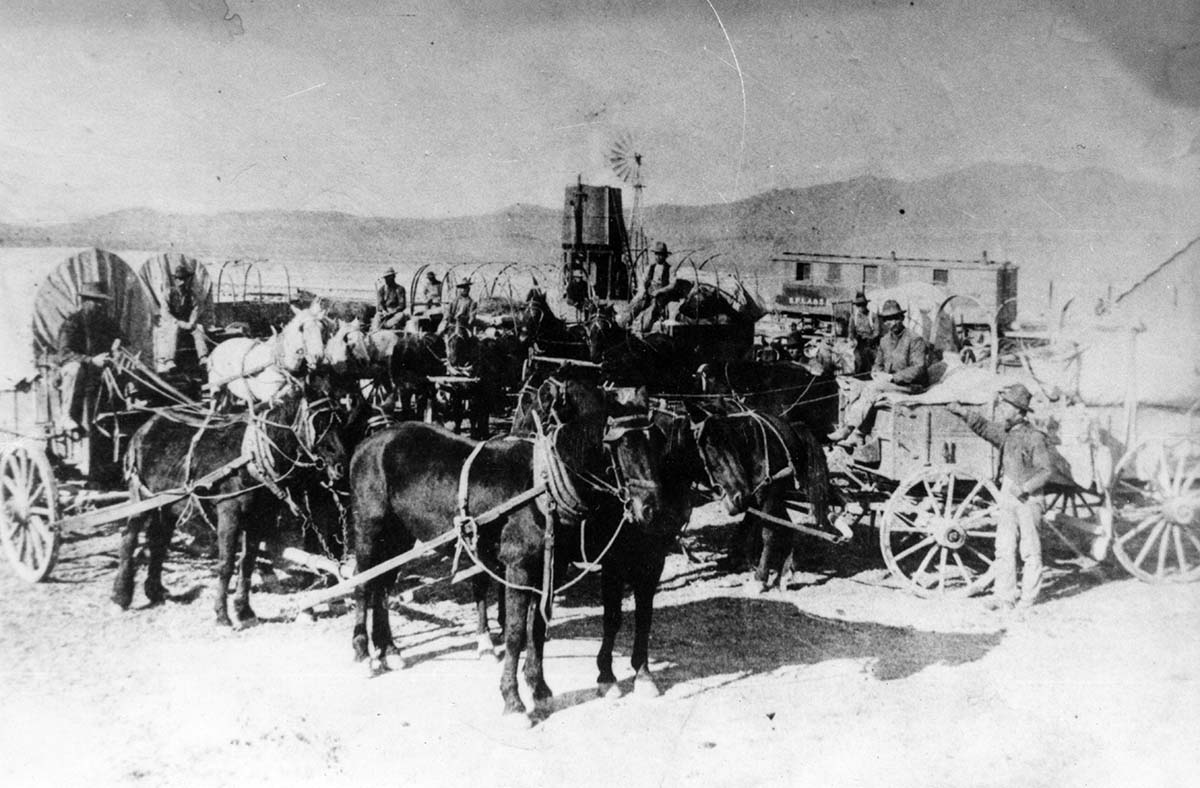 Freight wagons assembled at Lund, Utah. William Crawford in photo at extreme right. The wire in William Crawford's hand was used to take picture.