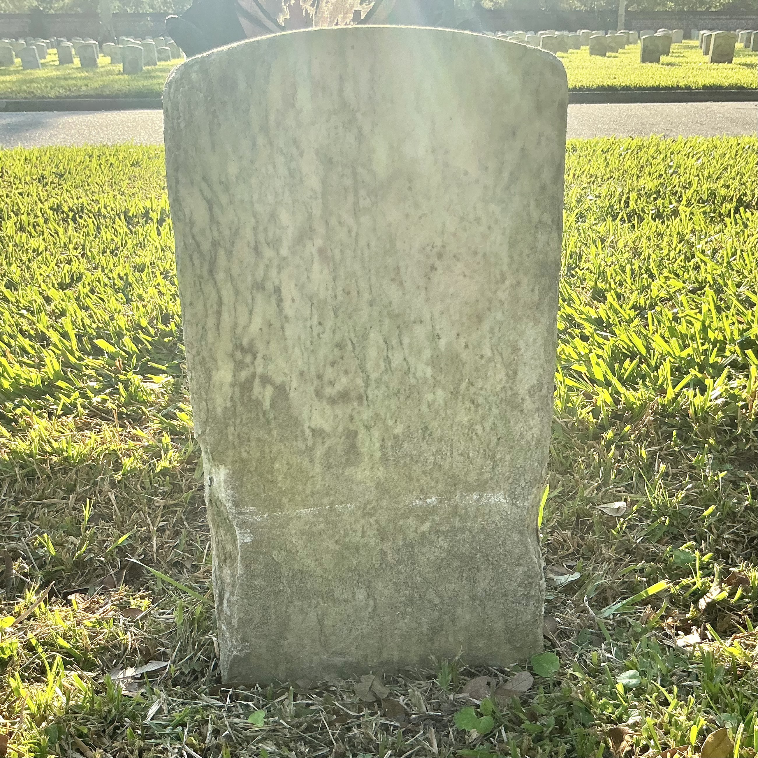 Back of historic upright marble headstone with recessed shield face.
