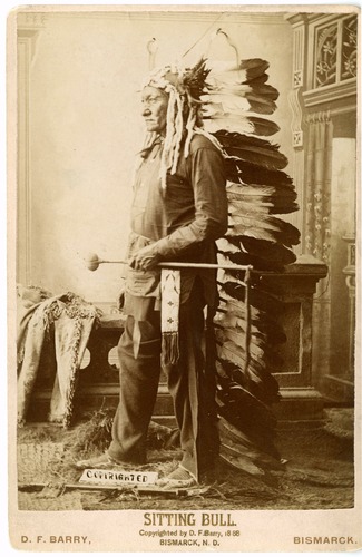 Sitting Bull in Long Feathered Headdress and Holding a Club