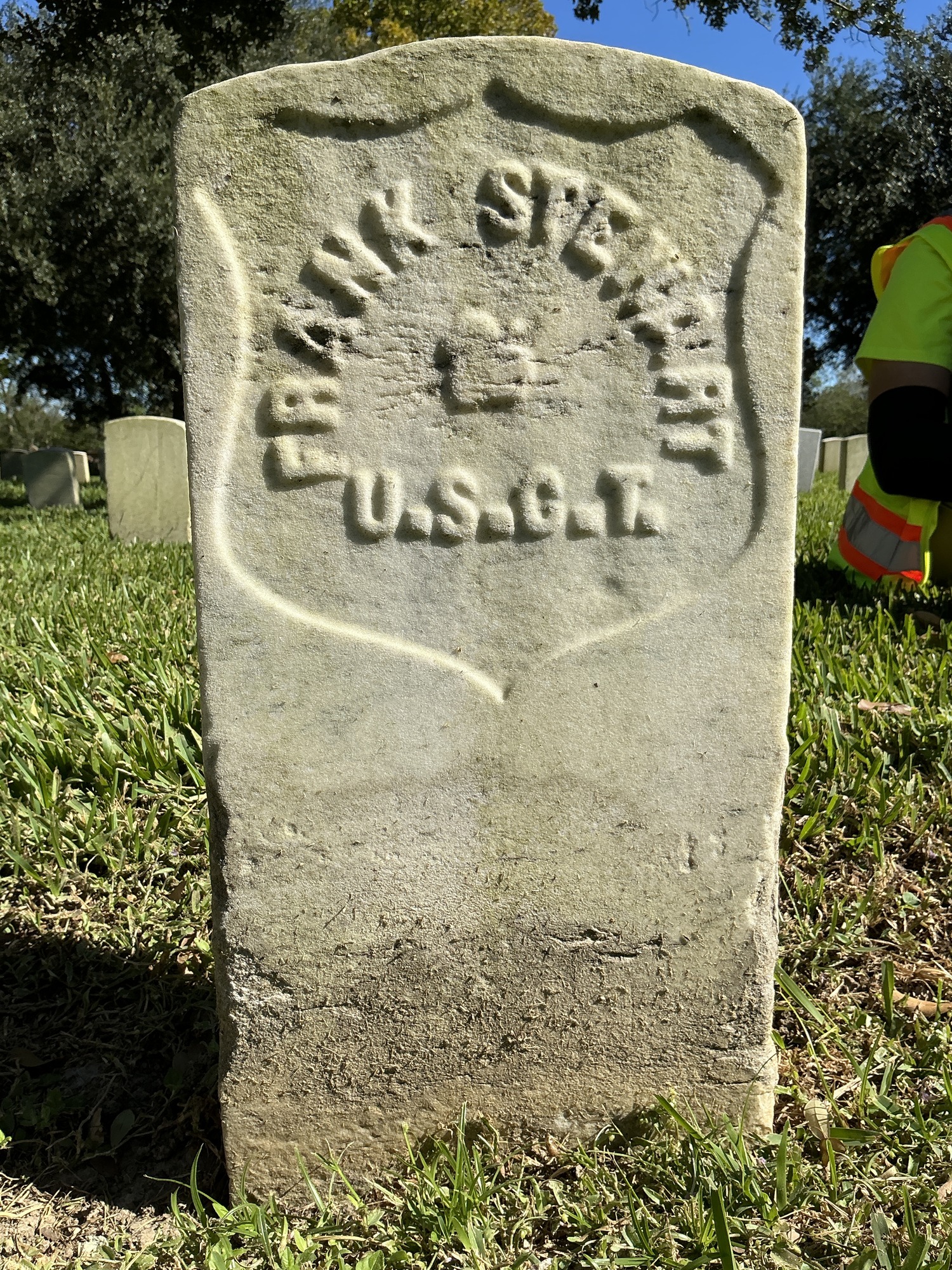 Back of historic upright marble headstone with recessed shield face.