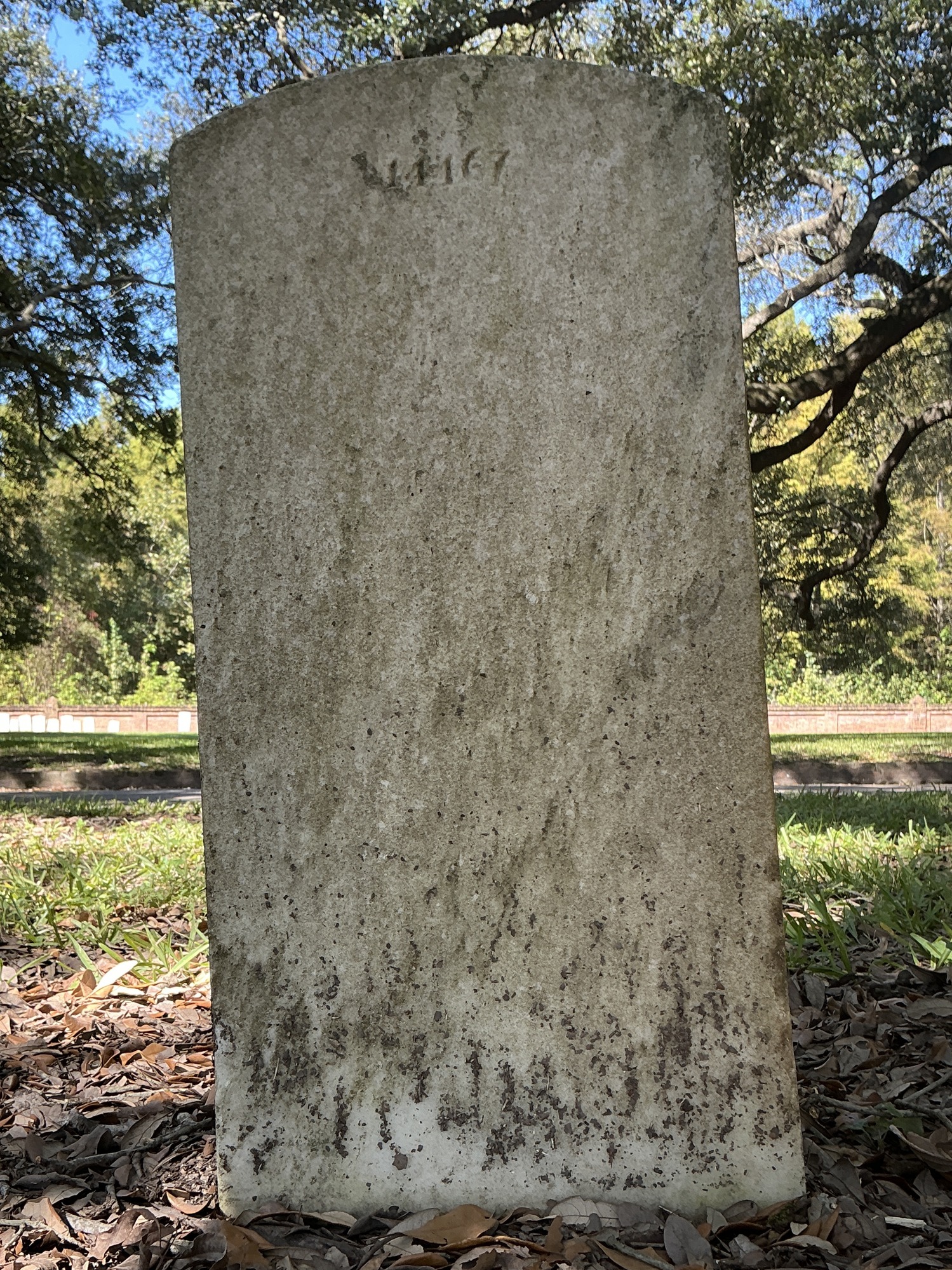 Back of upright marble headstone with flat face.