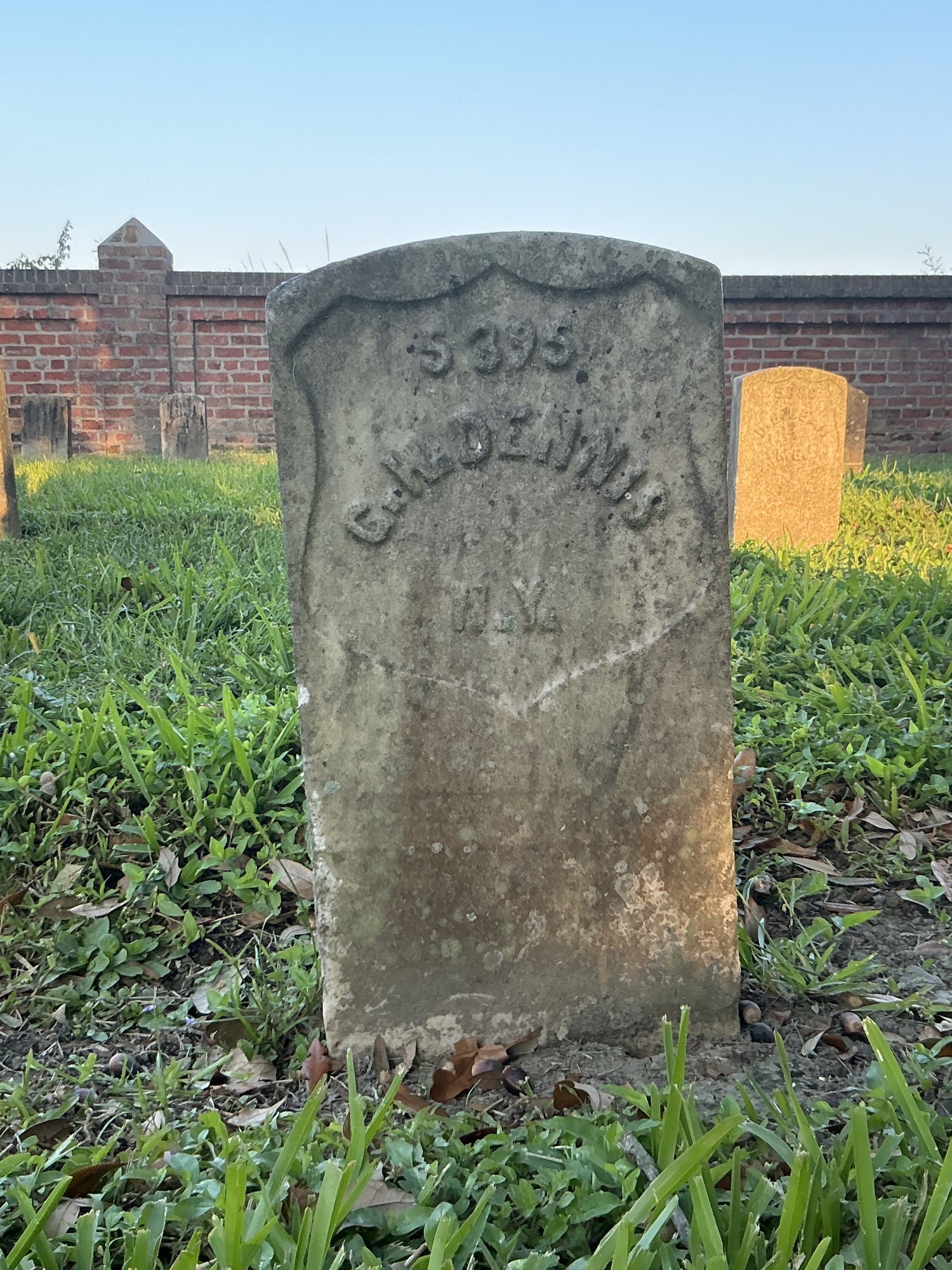 Front of historic upright marble headstone with recessed shield face.
