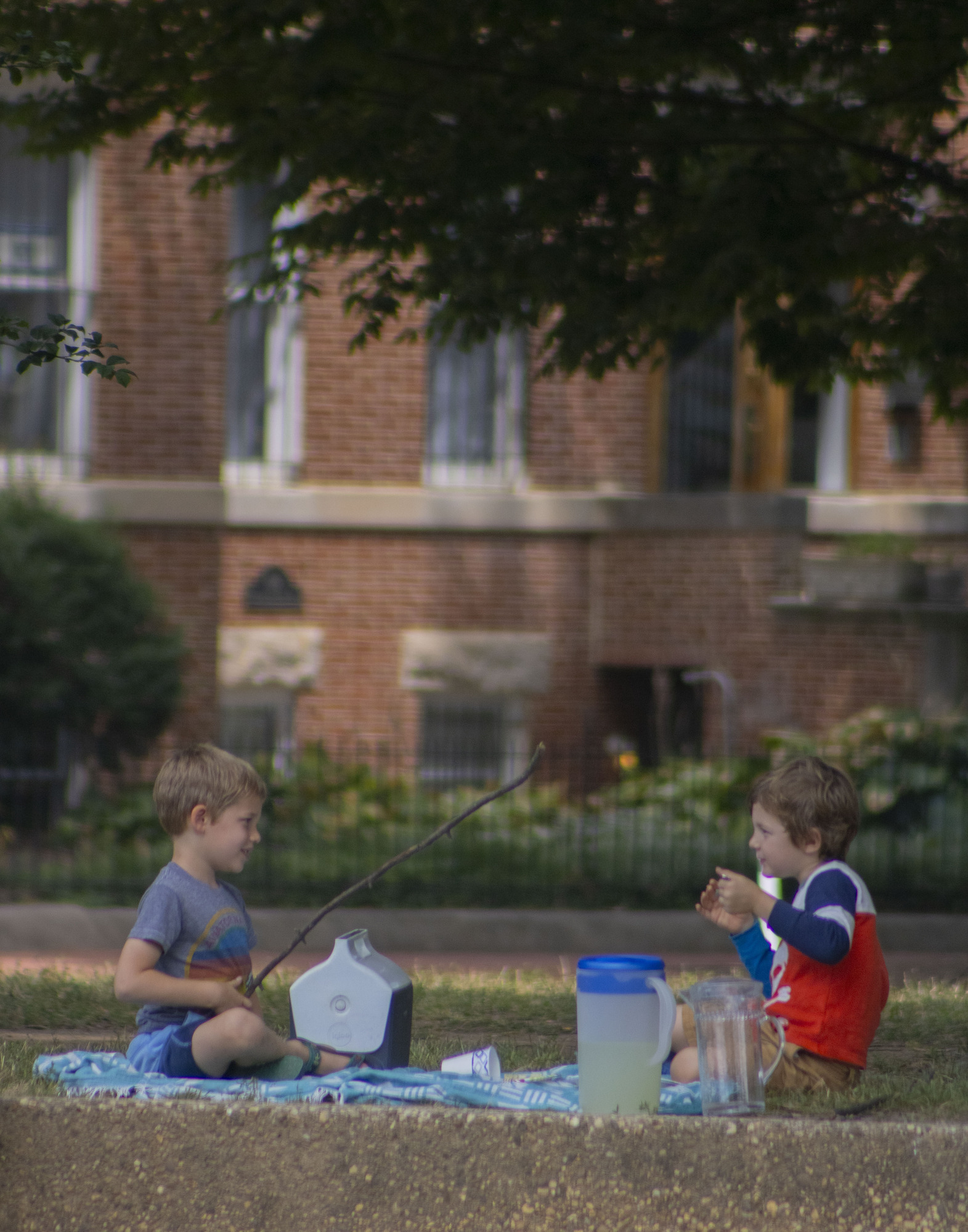 Two little boys sit at Lincoln Park and have a picnic.