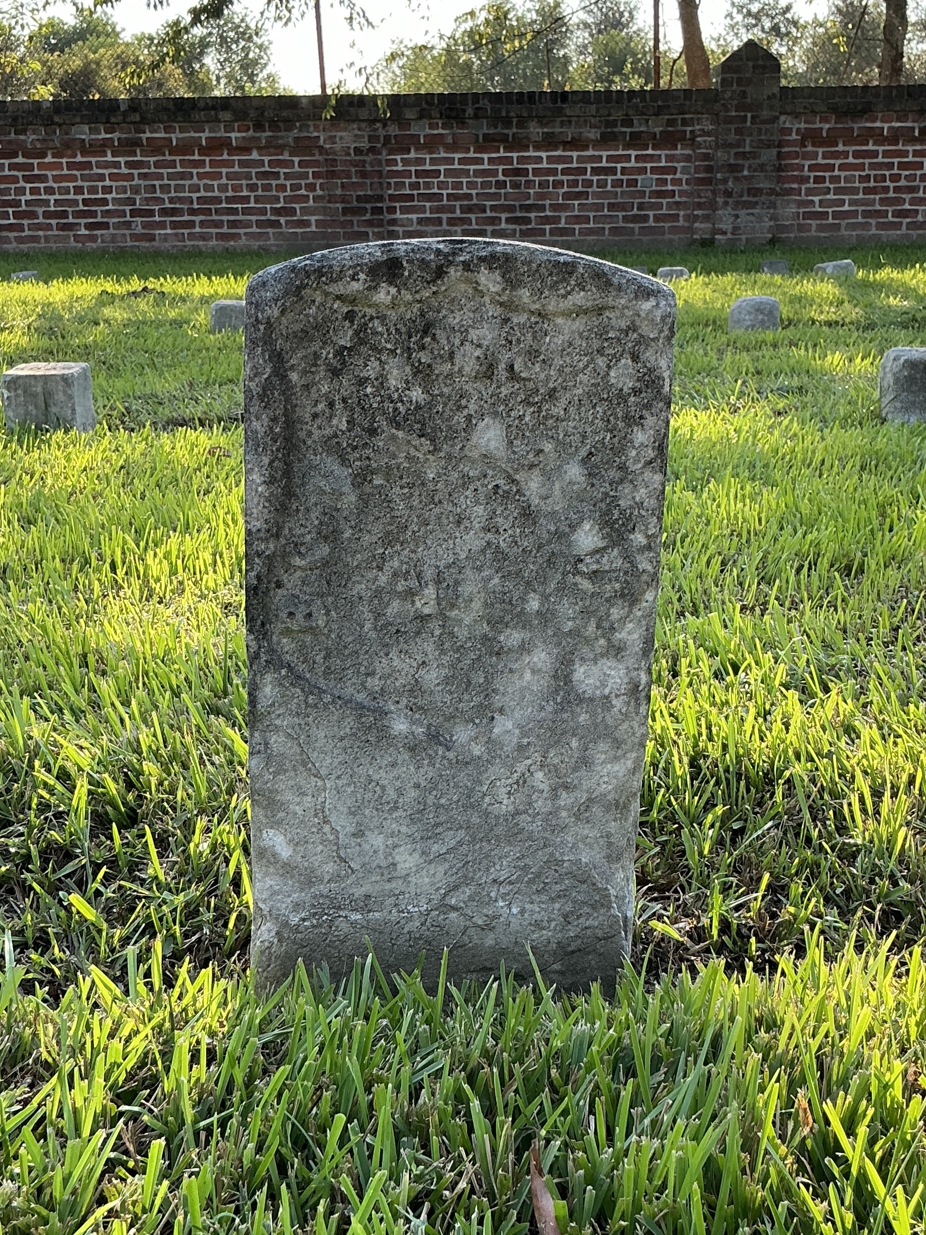 Front of historic upright marble headstone with recessed shield face.