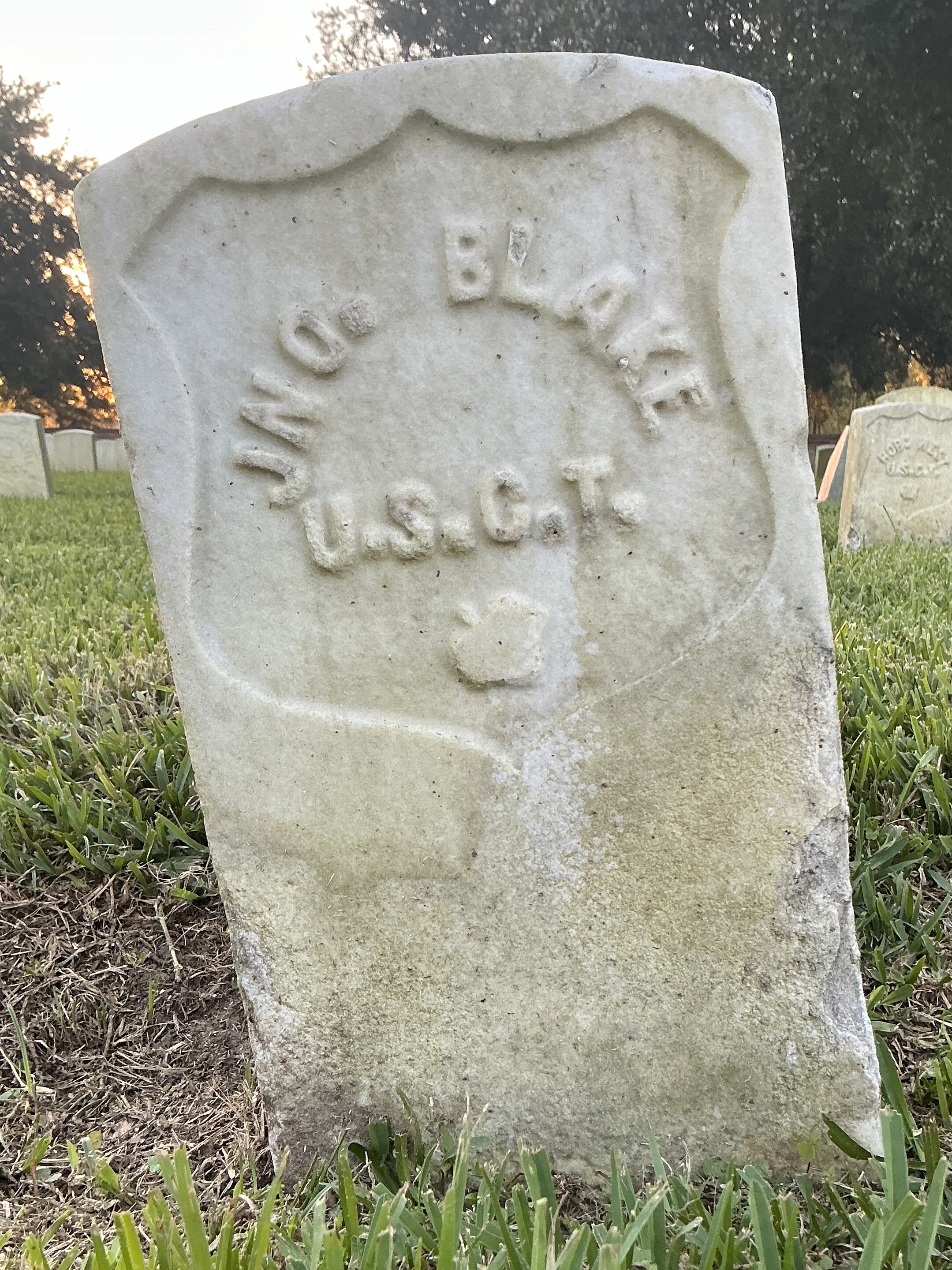 Back of historic upright marble headstone with recessed shield face.