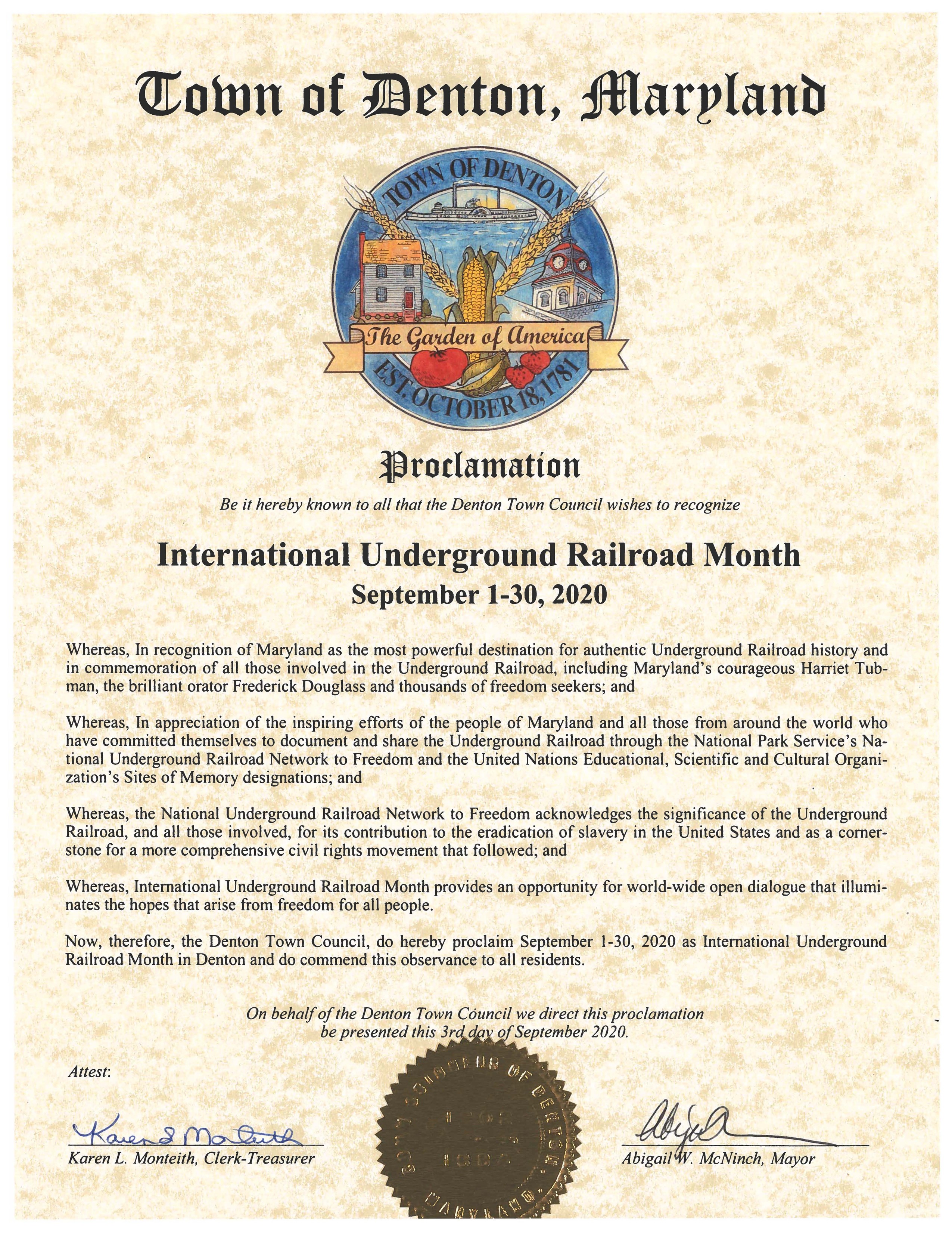 At the top of the page in ornate font is black text reading "Town of Denton Maryland." Directly underneath this font is a full color version of the town seal. Underneath the seal, also in ornate font, is text which reads "Proclamation." The rest of the proclamation is written in plain black text. At the bottom of the document is a gold seal, on either side of which is the signatures of the Clerk-Treasurer and the Mayor.