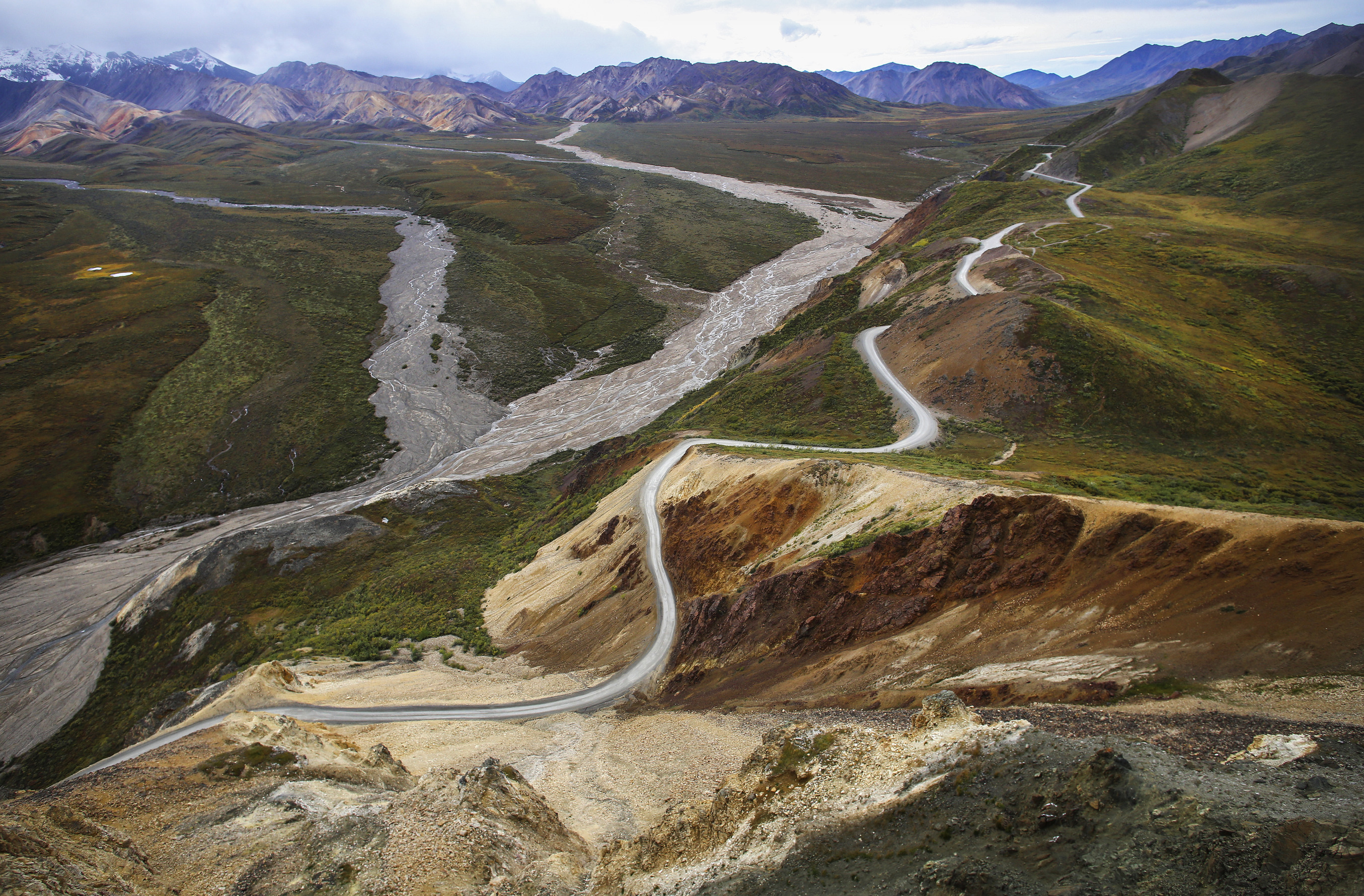 view of a dirt road winding up and along the side of a mountain