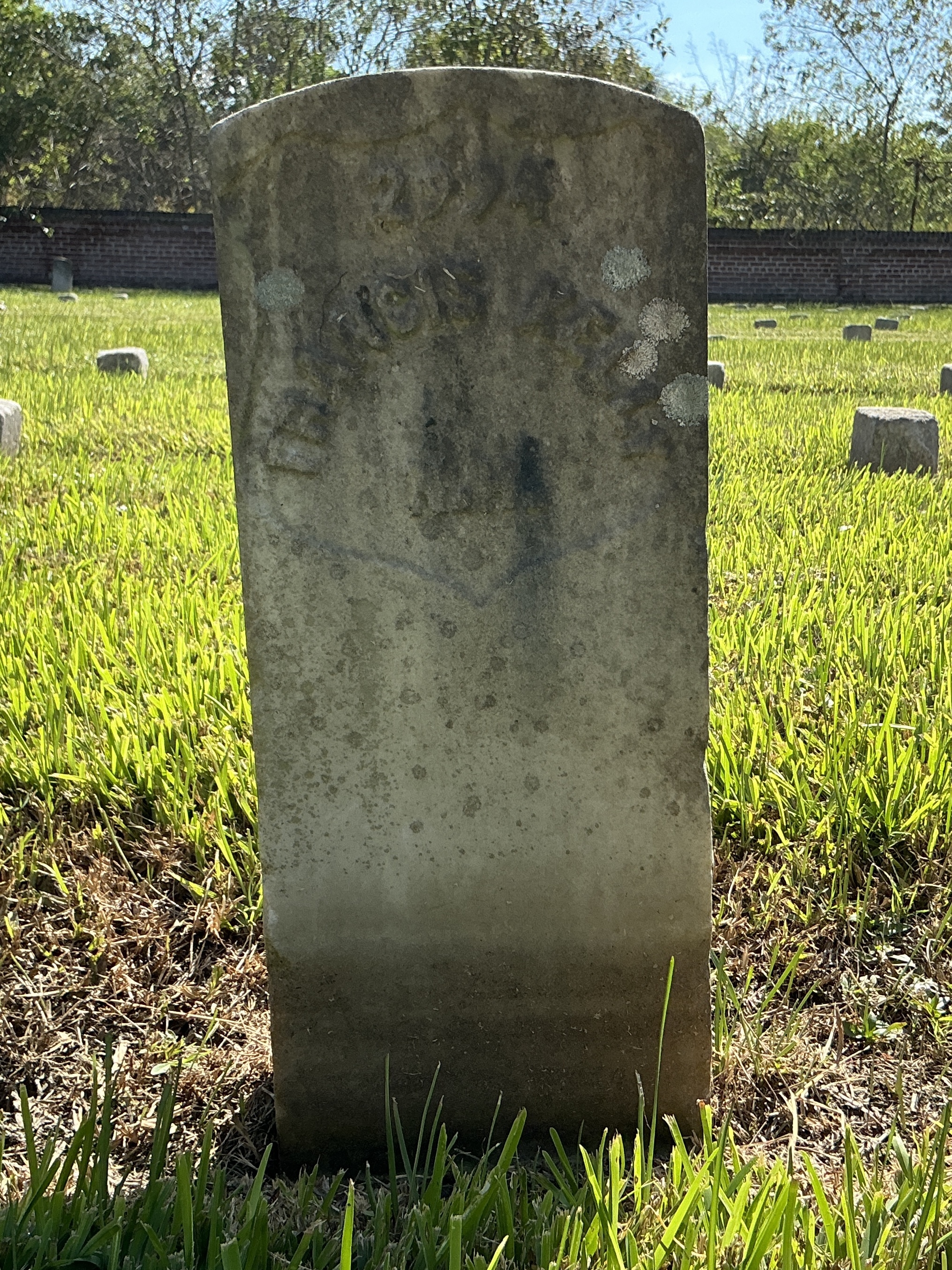 Front of historic upright marble headstone with recessed shield face.