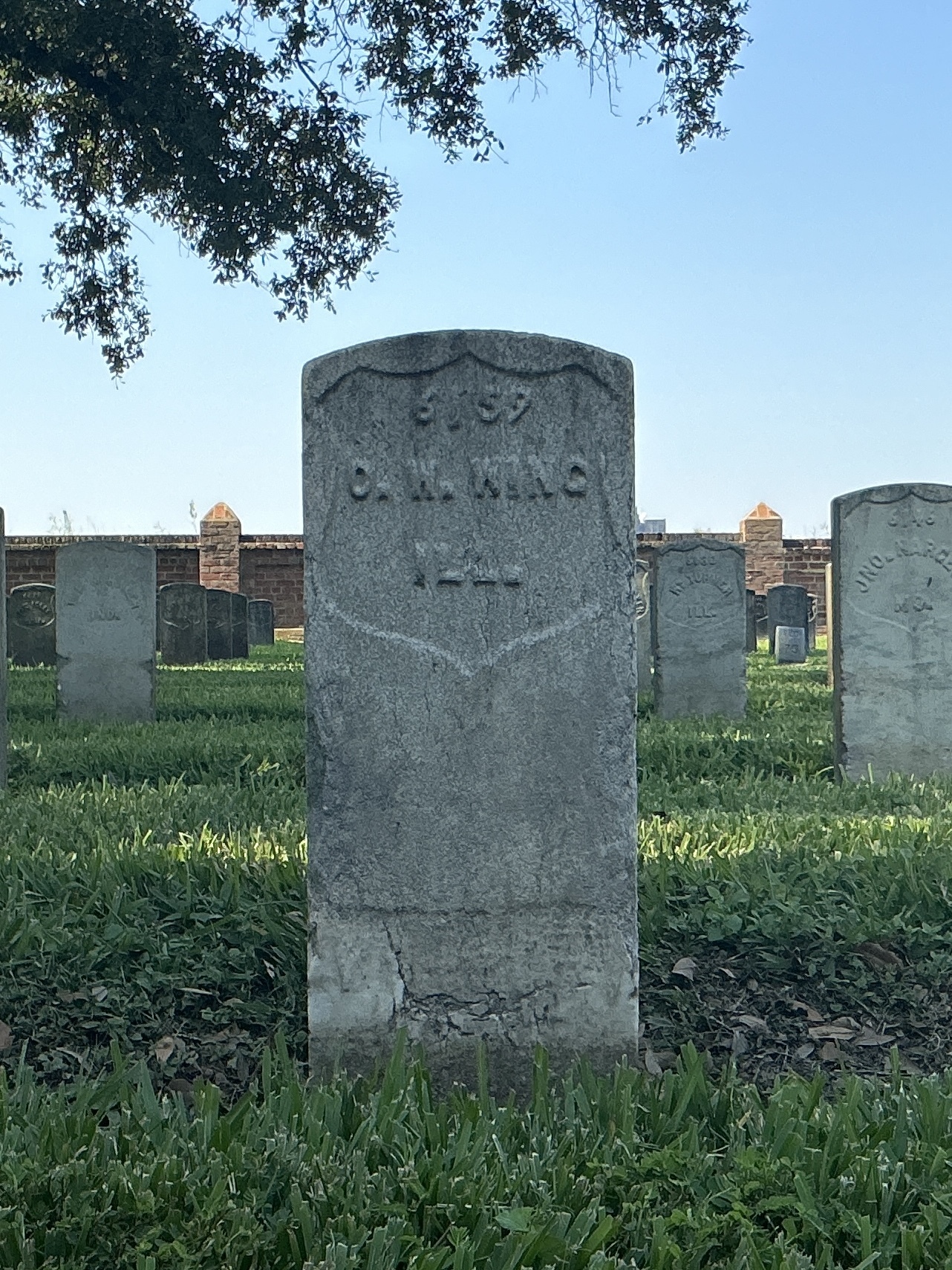 Front of historic upright marble headstone with recessed shield face.