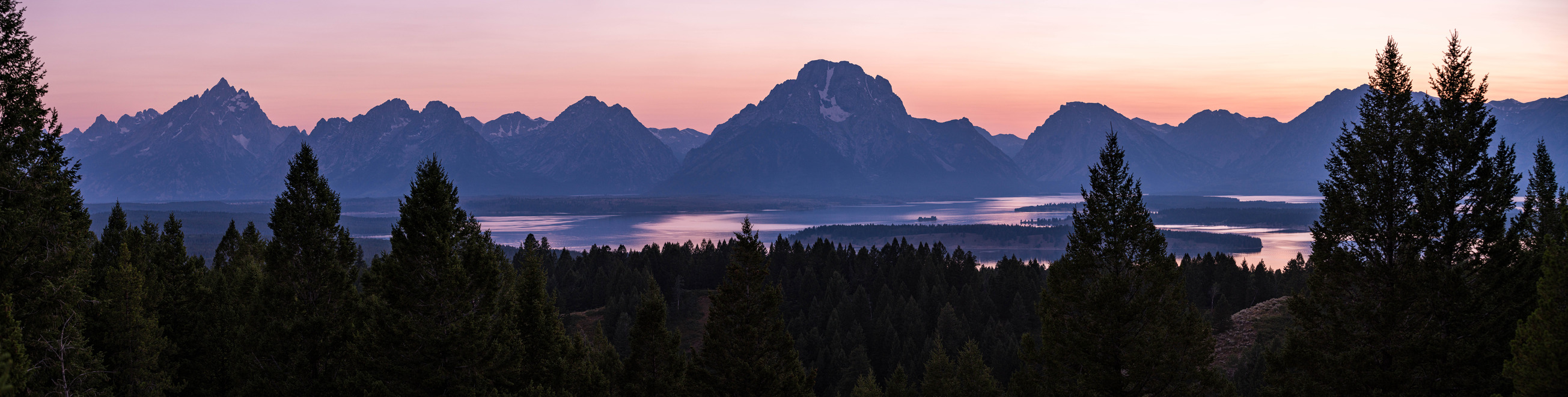 A mountain range with a lake at the base as viewed from an overlook.