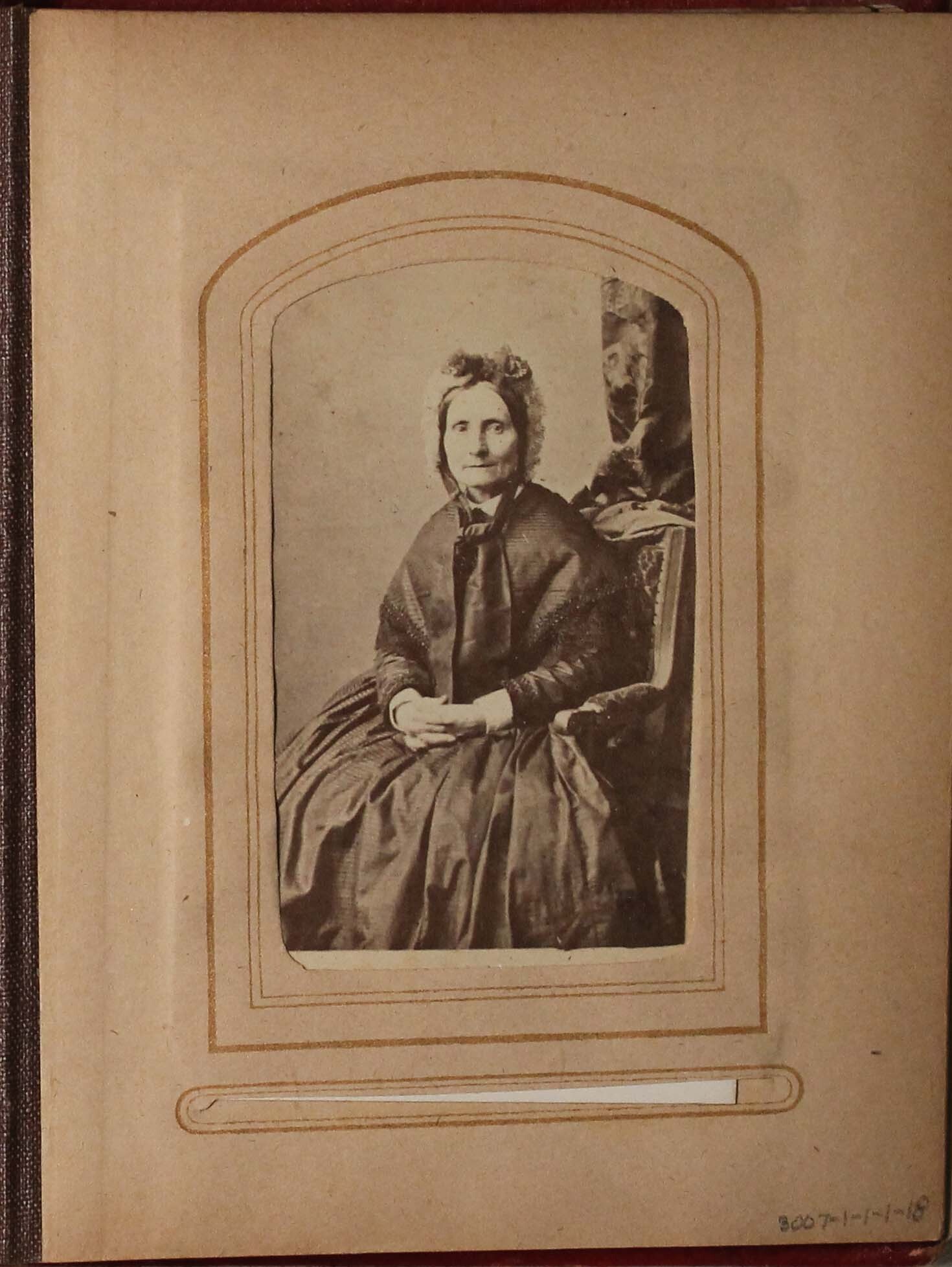 Black and white photograph of older woman sitting in chair.