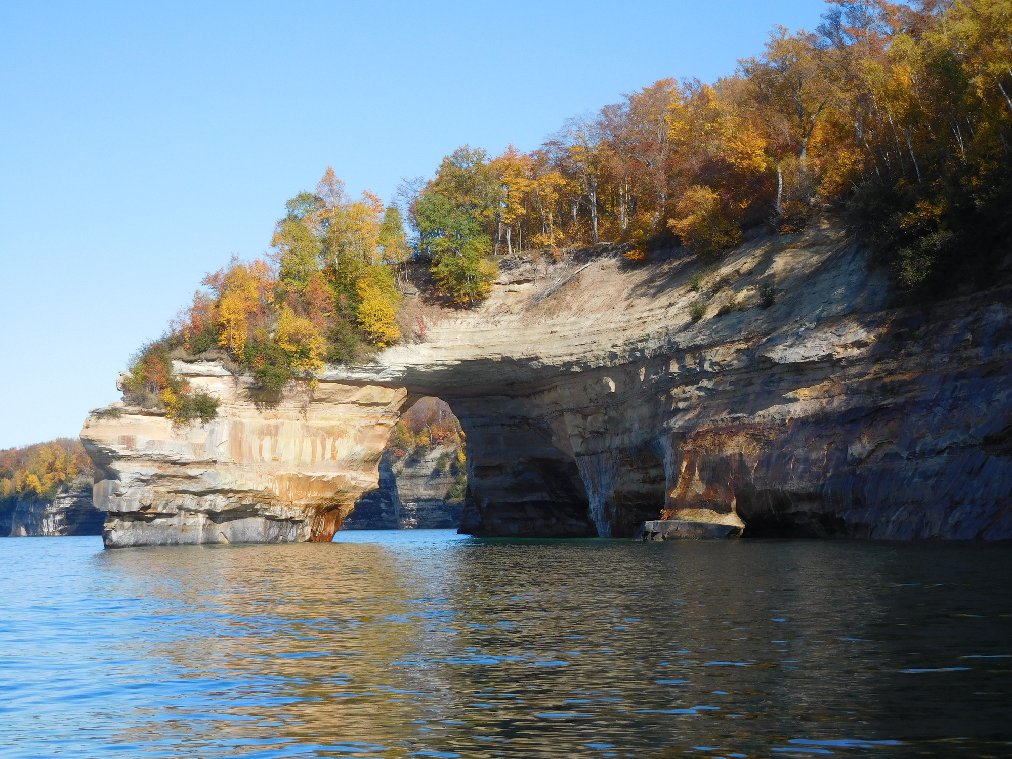 Sandstone rock archway coming out of the cliffs along Lake Superior
