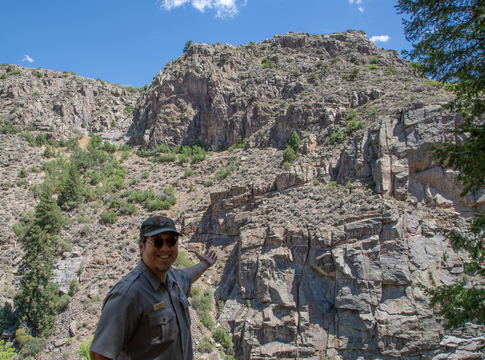 Ranger extending arm towards a canyon wall