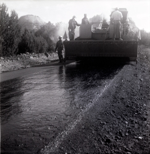 Men operating construction vehicles during chipsealing of Kolob Canyon Road.