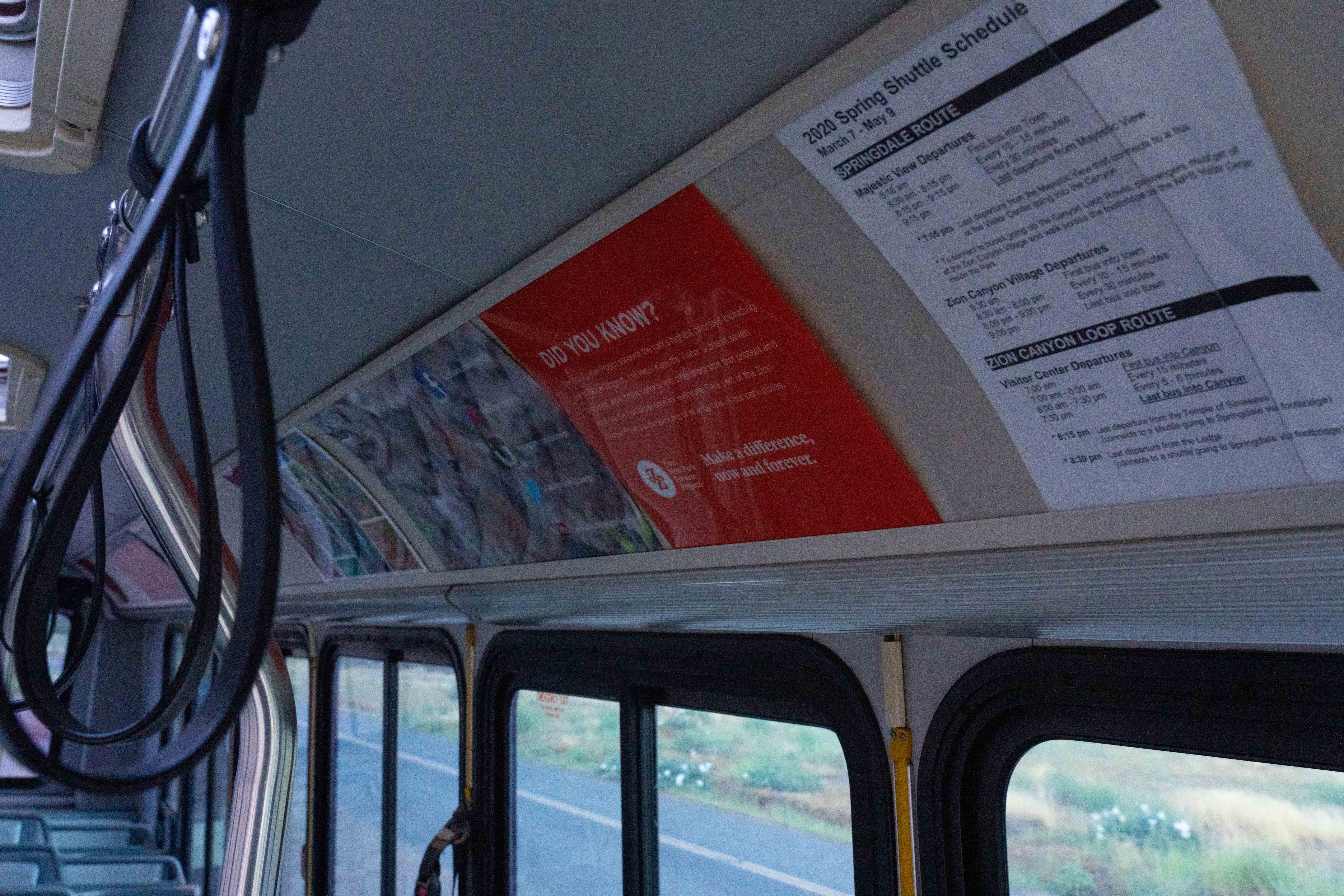 Close up photo of multiple signs that are on display inside the Zion shuttle buses above the windows.